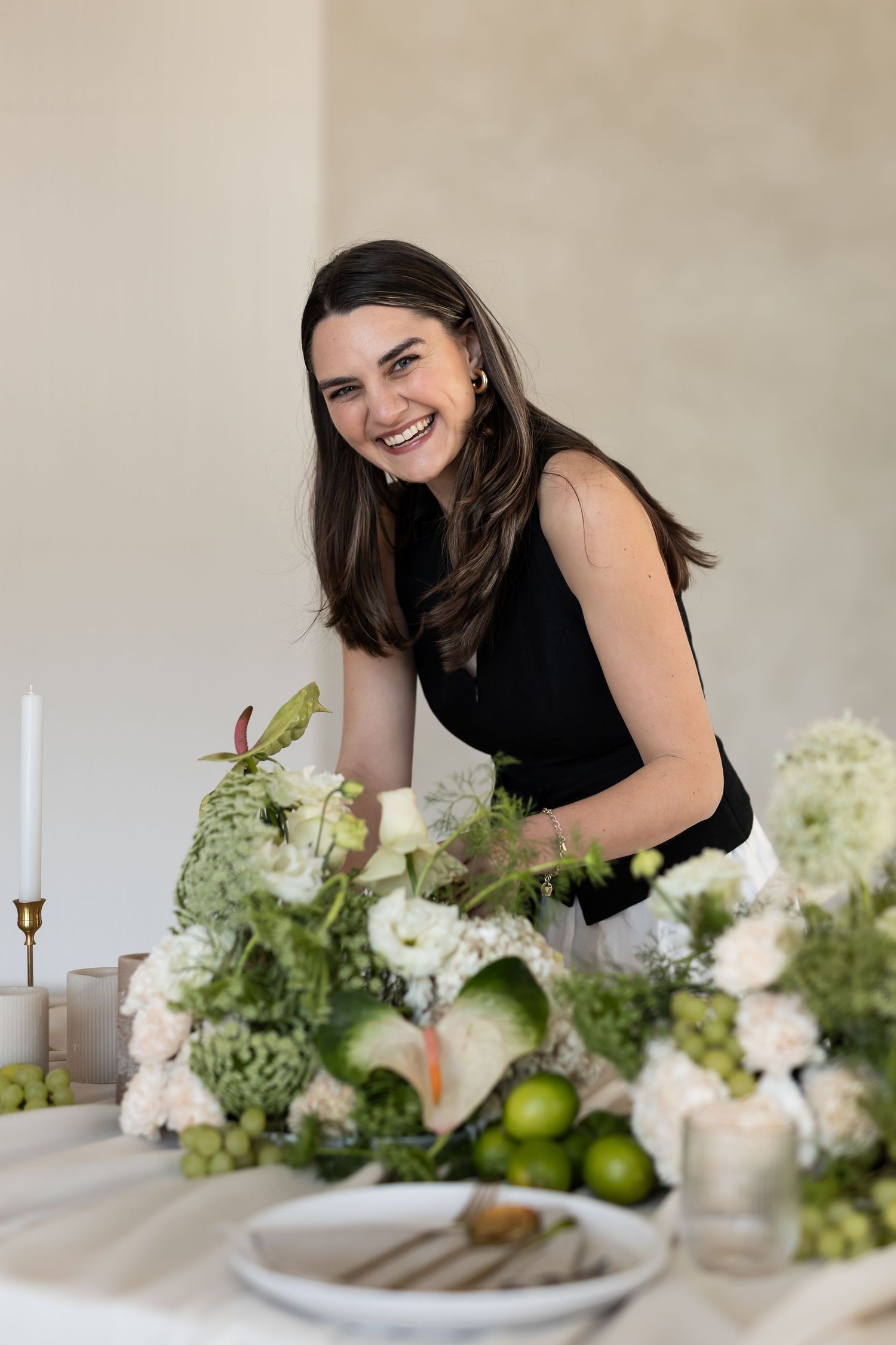 A series of elegant floral centerpieces with white hydrangeas and greenery on a natural linen table setting.