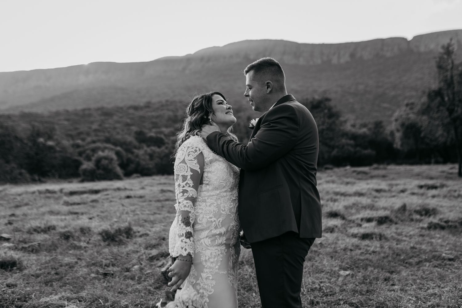 Black and white romantic wedding portrait with mountainous backdrop.