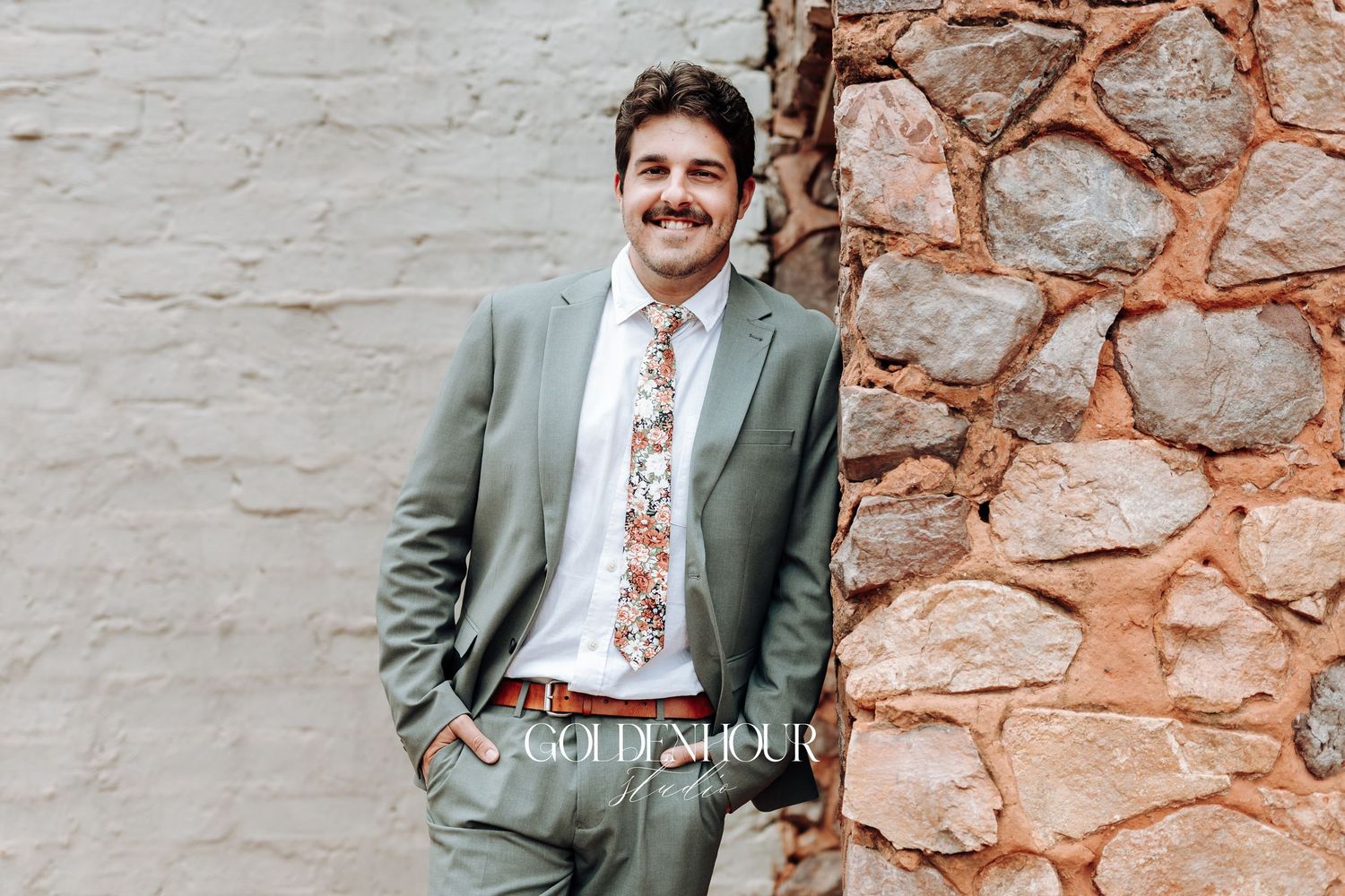 Formal wedding portraits against a rustic stone wall backdrop.