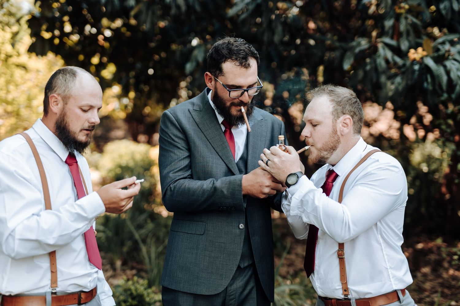 Wedding party members enjoy drinks and casual moments during outdoor photography session.