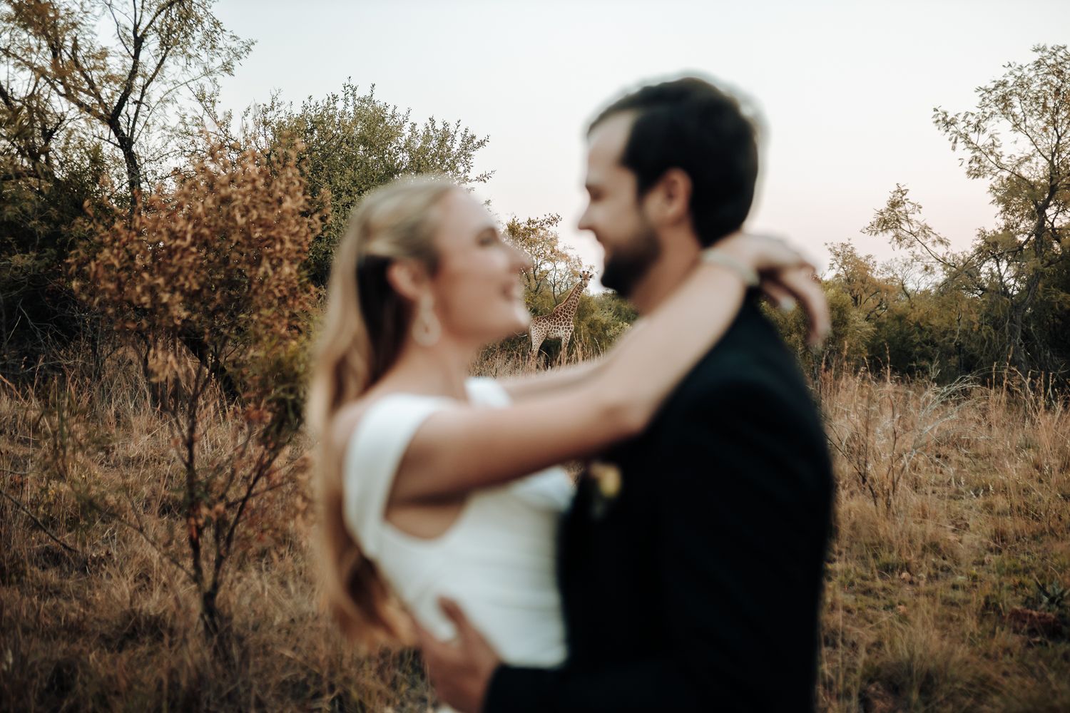 An intimate embrace captured in soft focus during a golden hour wedding photoshoot.