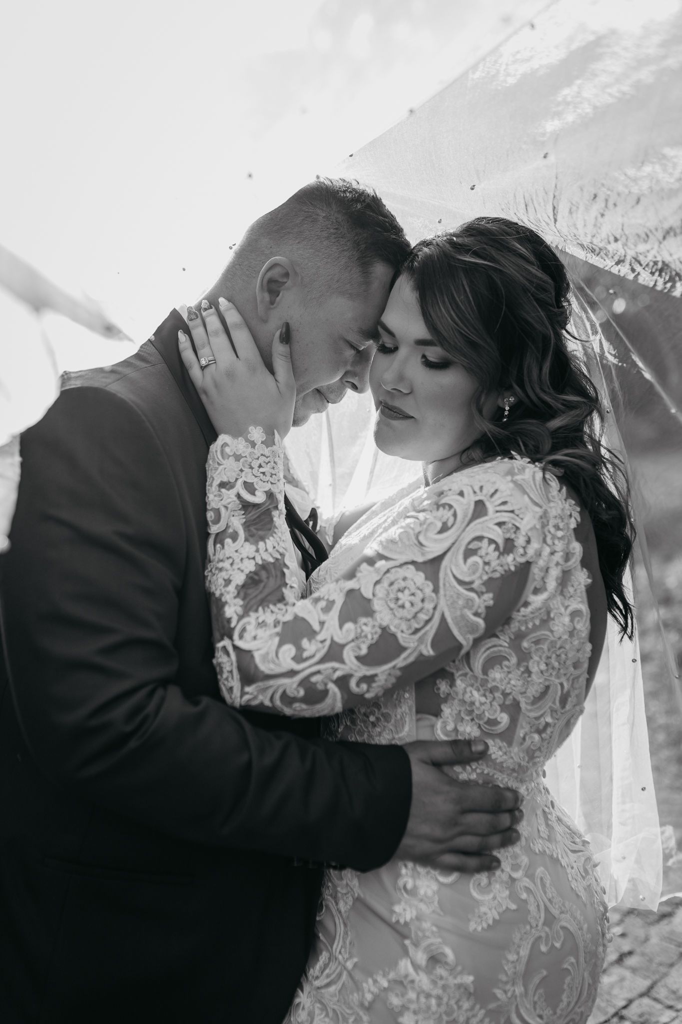 Intimate black and white portrait of couple sharing emotional wedding moment.