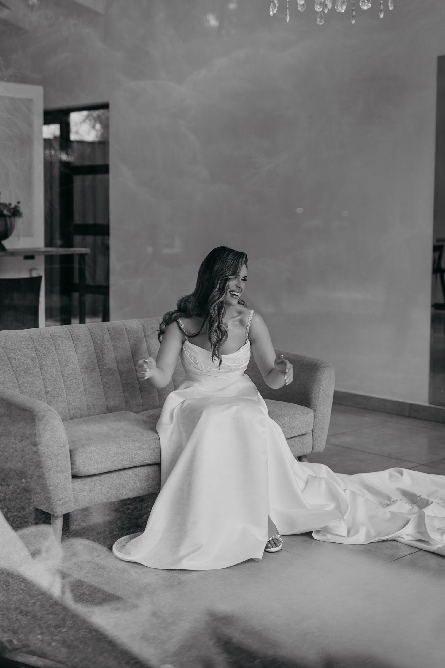 Wedding dress preparation photos in black and white on a gray couch.