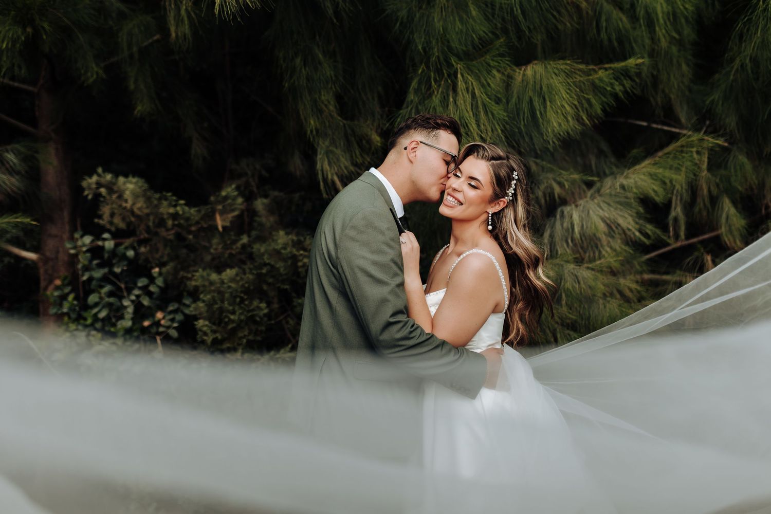 A romantic couple shares an intimate moment in a lush garden setting during their wedding photoshoot.
