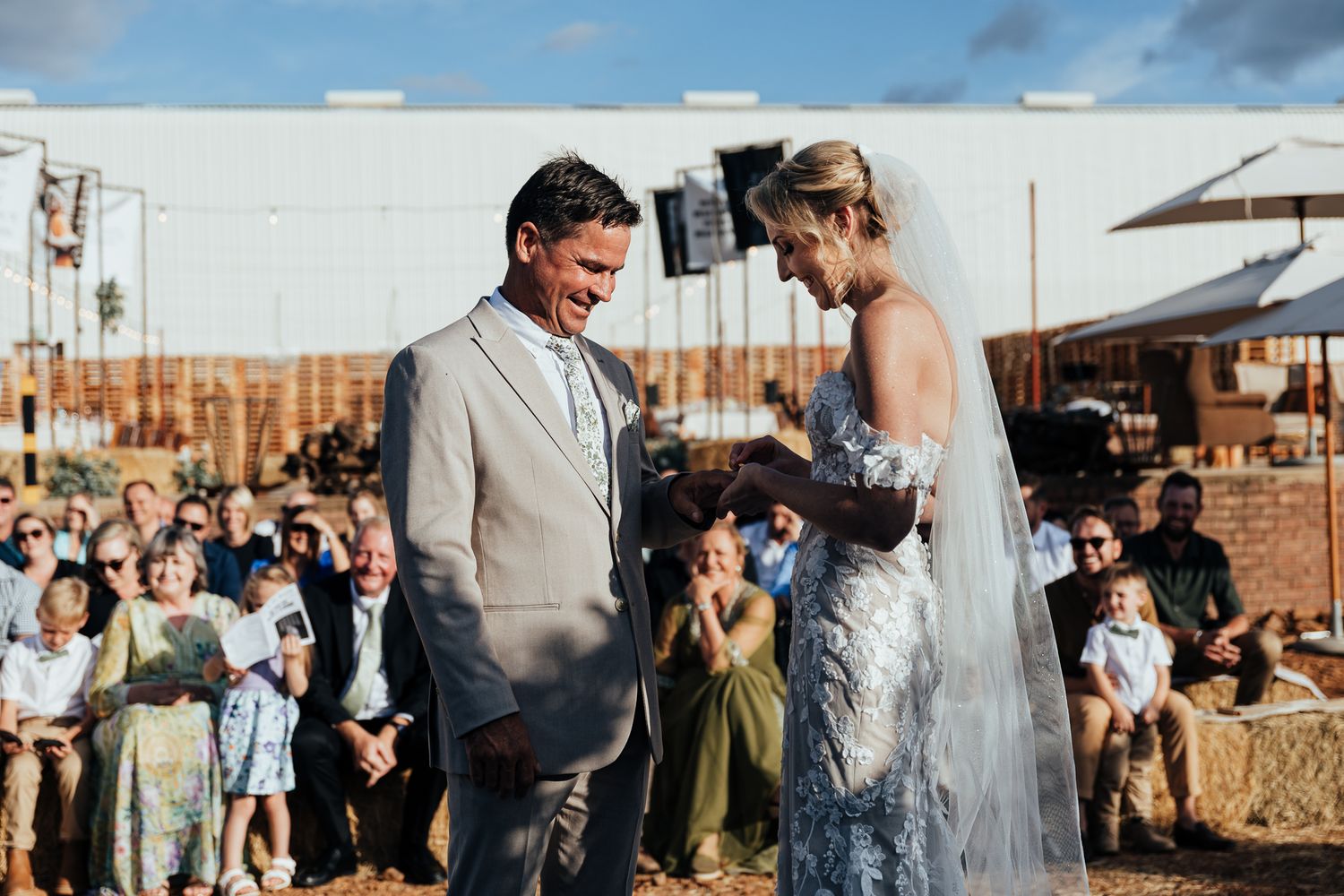 Outdoor wedding ceremony with couple sharing a moment while guests look on.