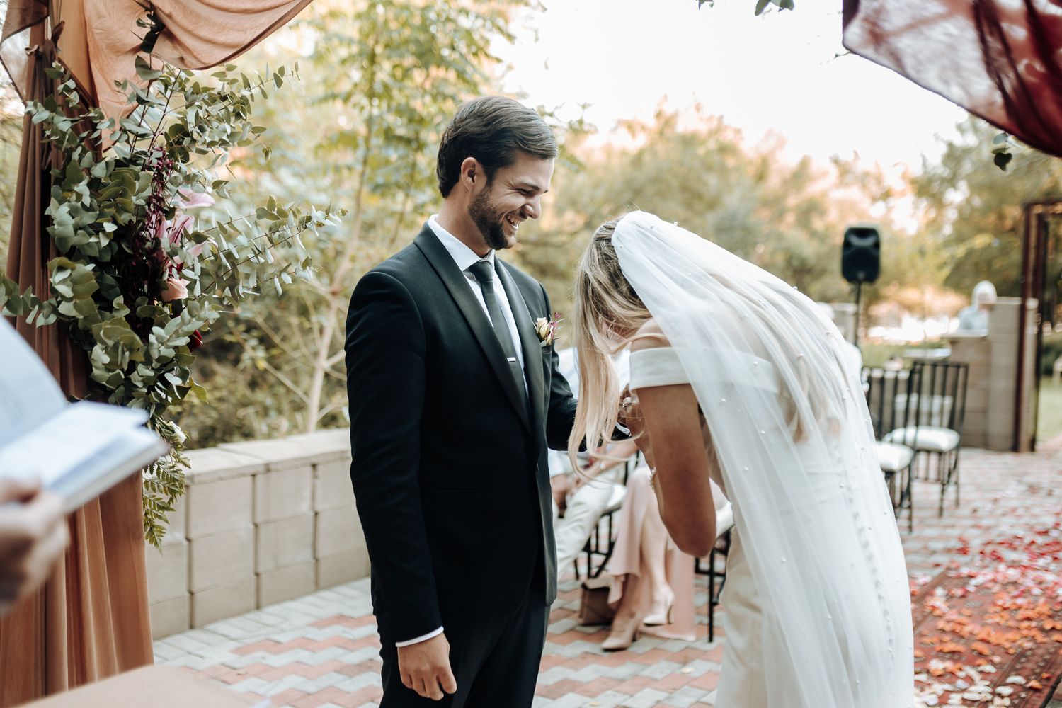 An intimate moment during an outdoor autumn wedding ceremony.