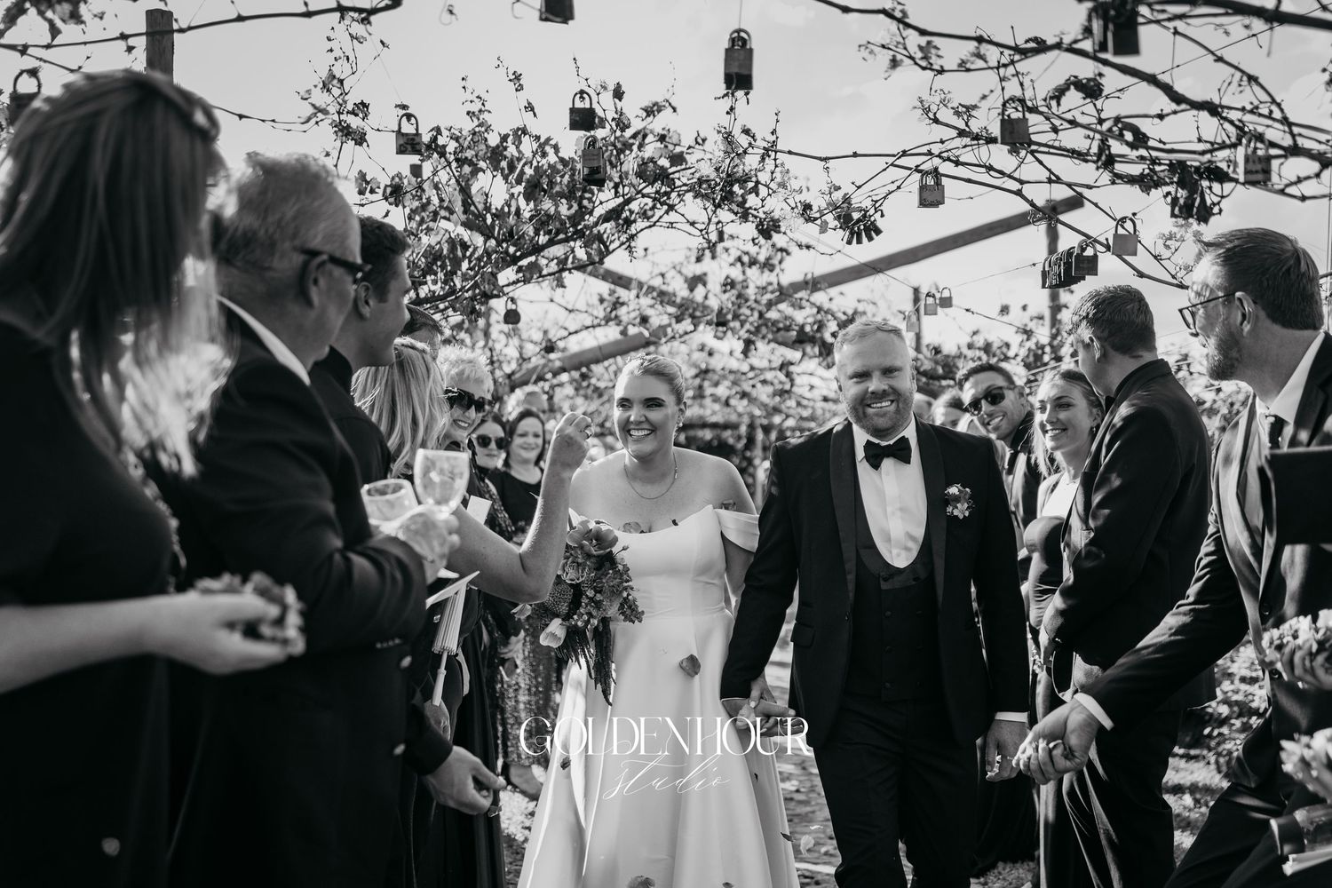 Black and white wedding photos showing candid moments during a celebration under blossoming trees.
