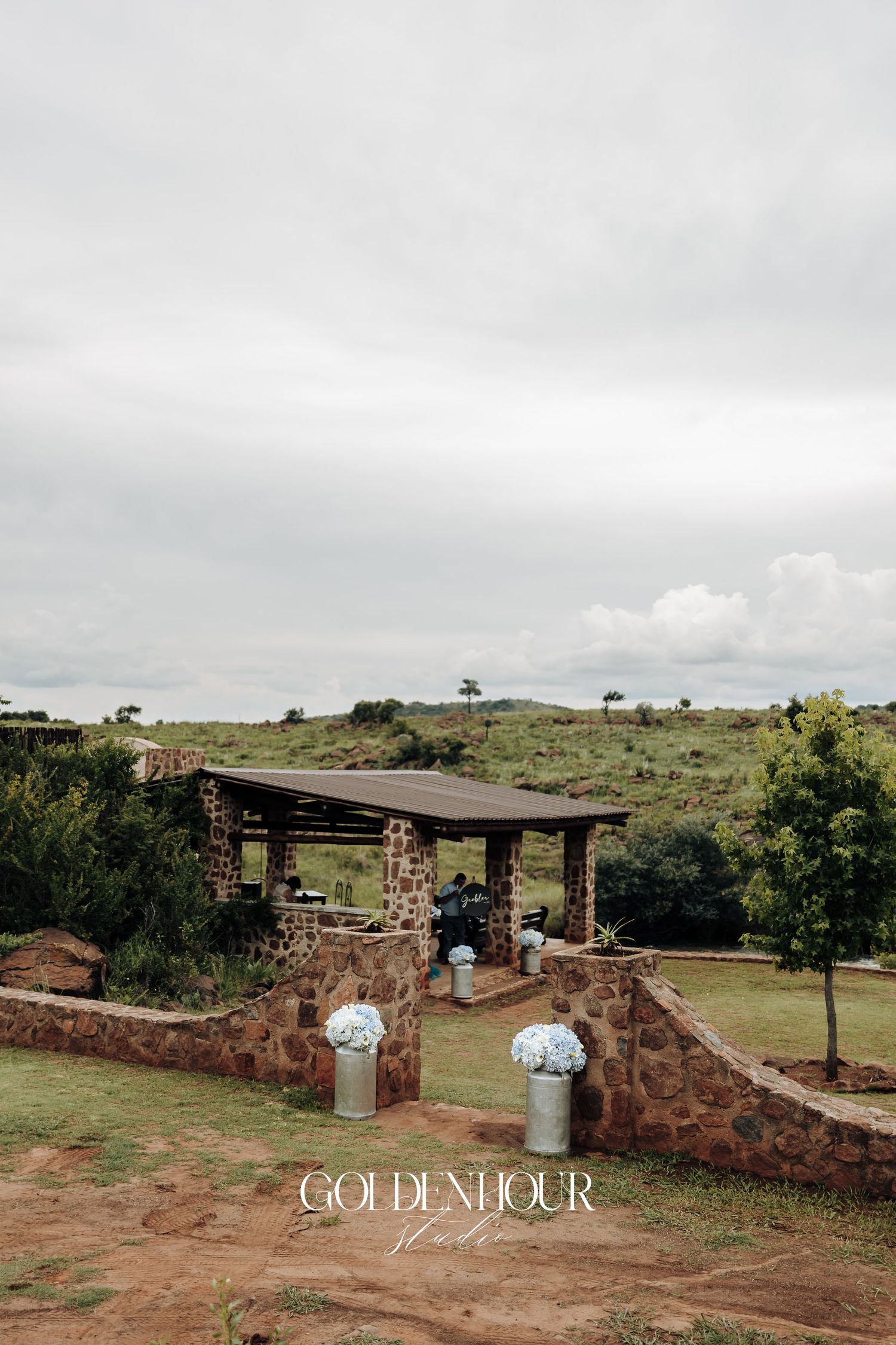 Rustic stone venue with outdoor seating area under cloudy skies.