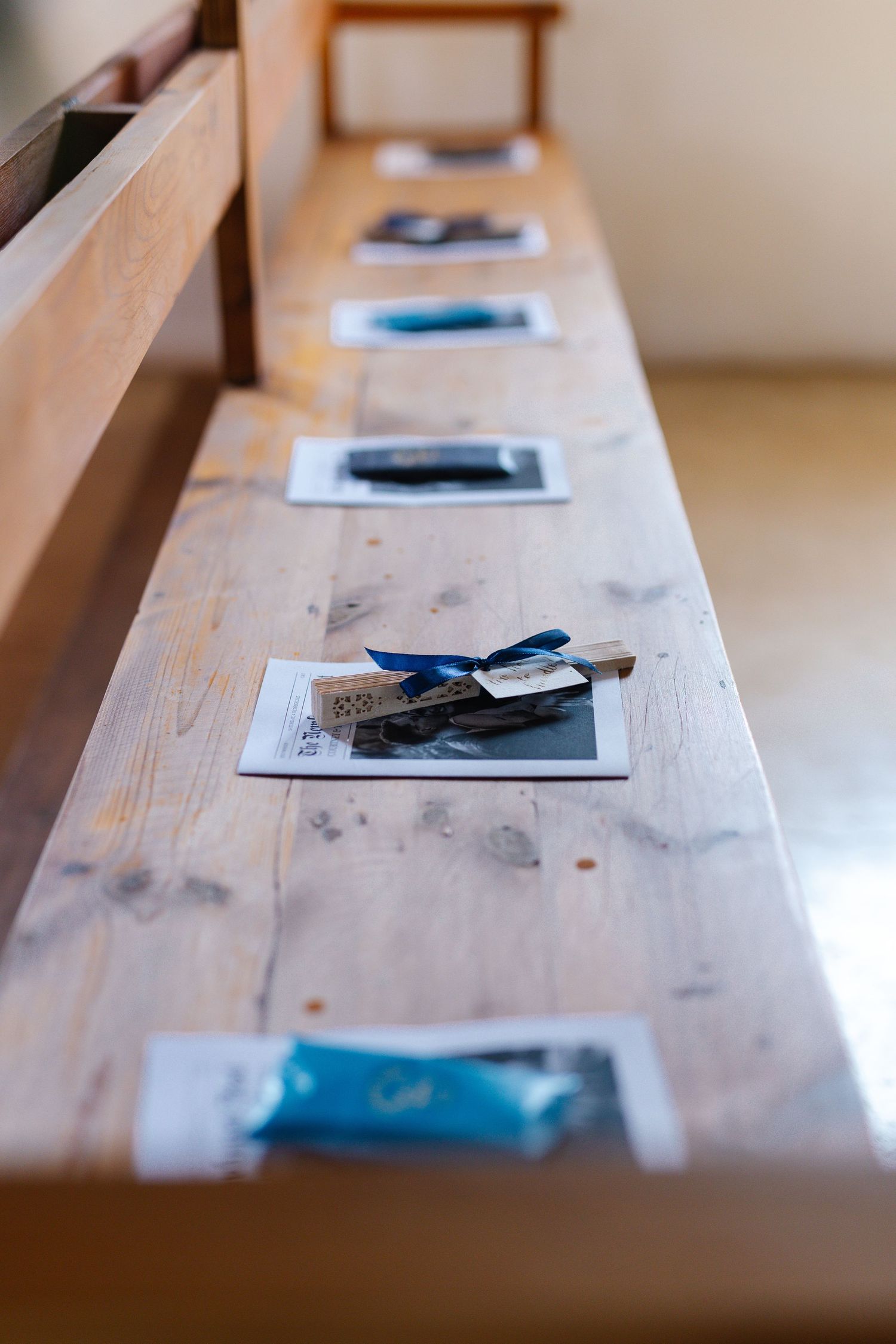 Multiple cell phones and electronic devices lined up on a weathered wooden table surface in shallow focus.