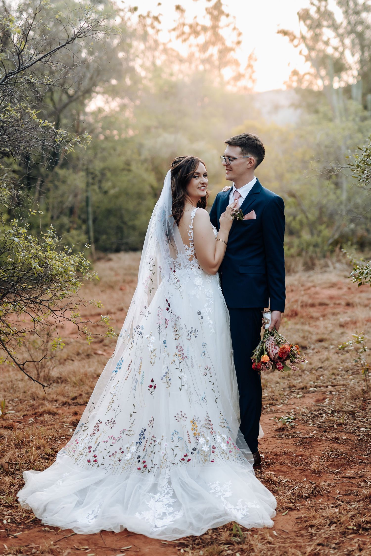 A romantic outdoor wedding scene with a flowing lace gown and autumn foliage creating a warm, ethereal atmosphere.