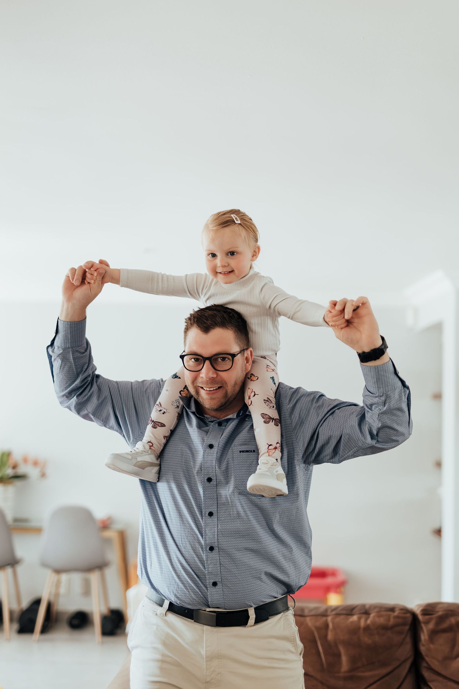 Parent and child playing together in modern living room with joyful expressions and energetic movements.