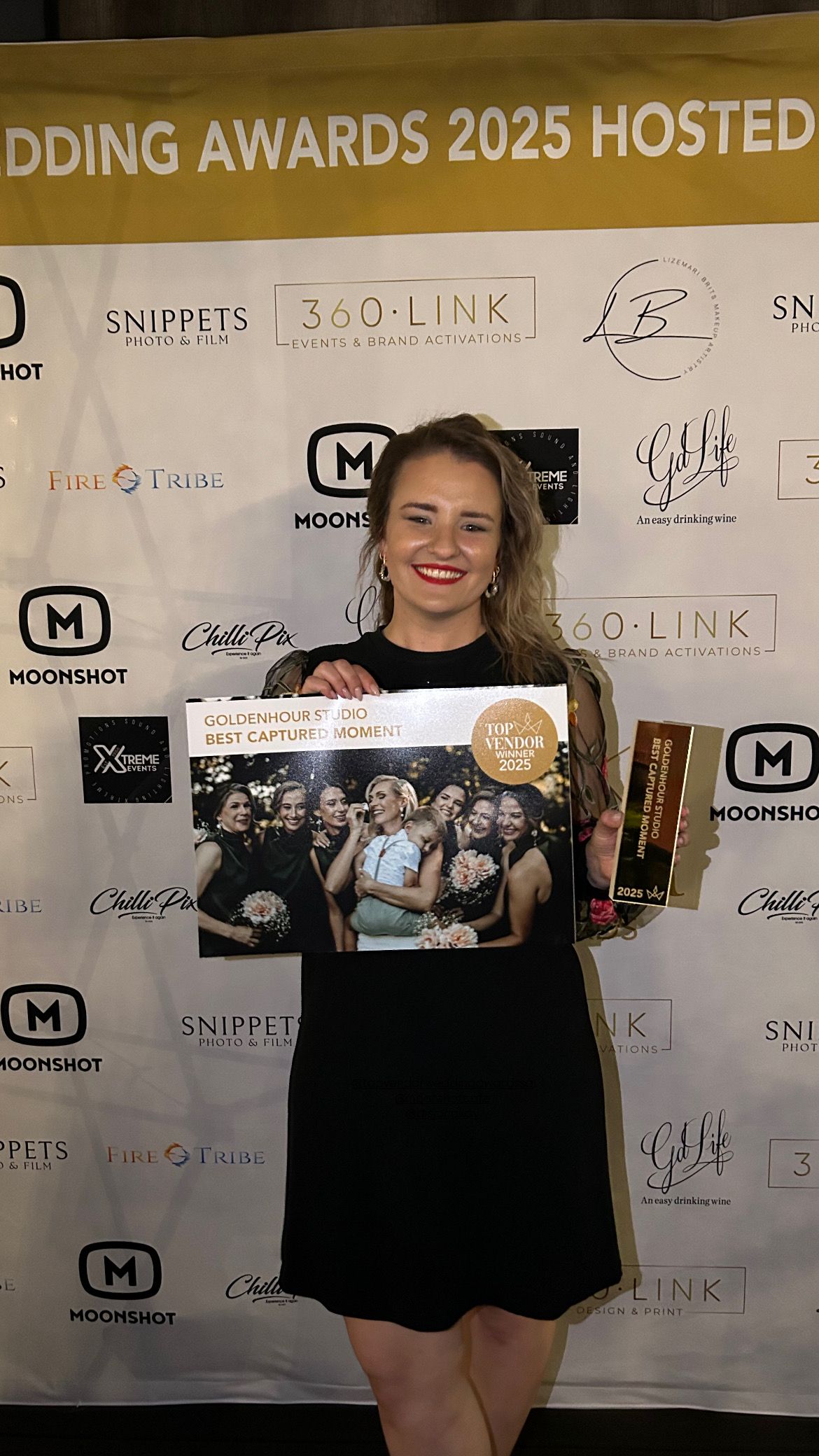 A red carpet photo session in front of a sponsorship backdrop showcasing multiple brand logos.