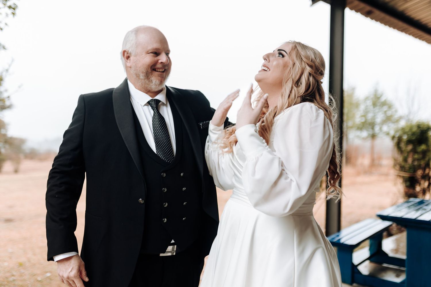 Joyful wedding couple sharing a lighthearted moment during their outdoor photo session.