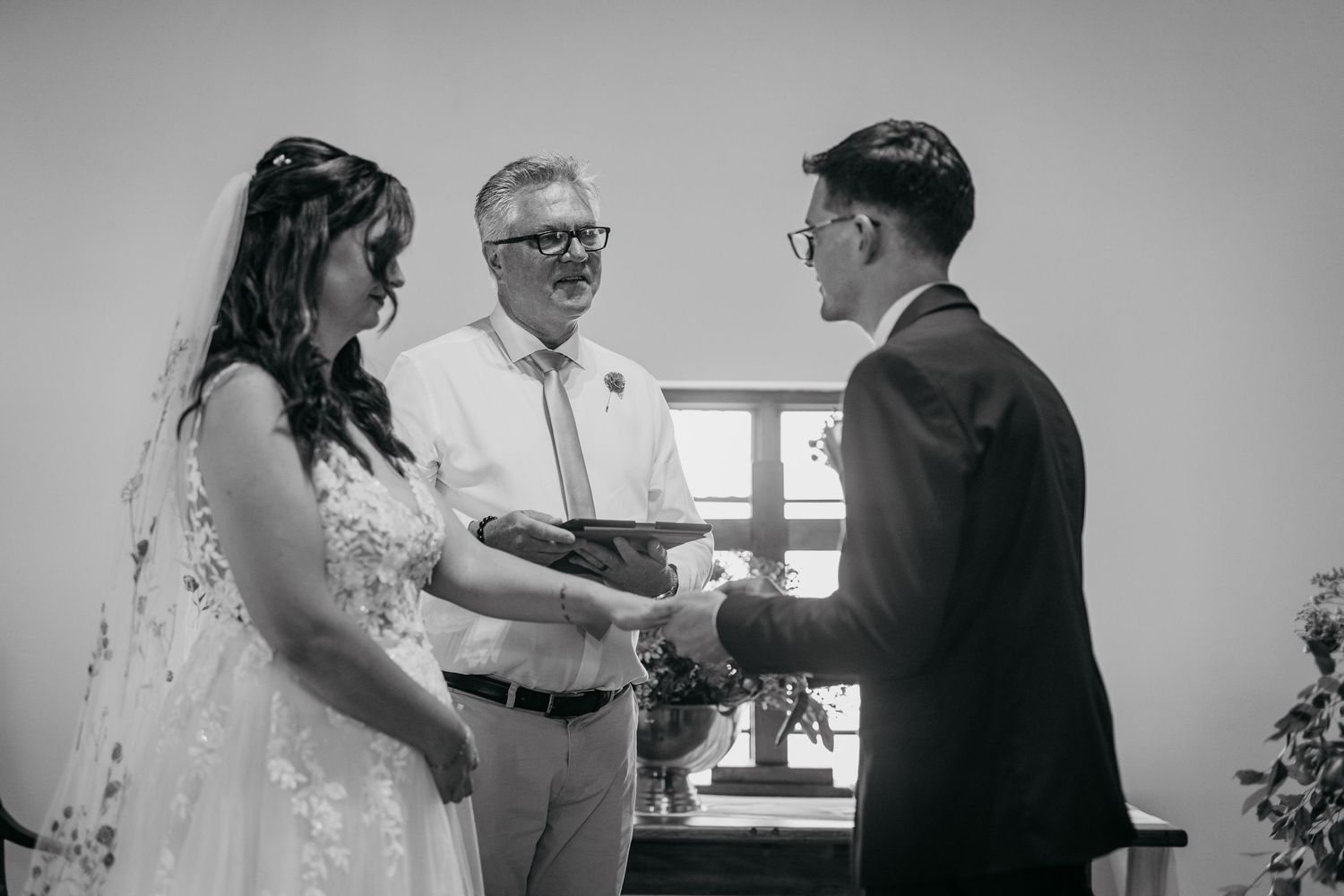 A black and white wedding photo collage showing intimate moments between couples and guests during a celebration.
