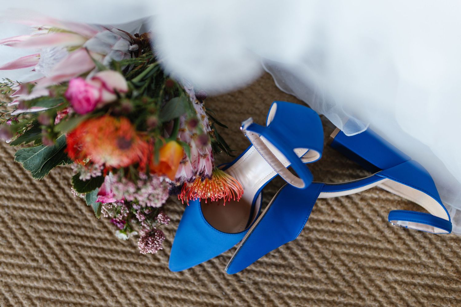 A series of seven images showing colorful flowers and blue ribbons arranged on a textured rope background.