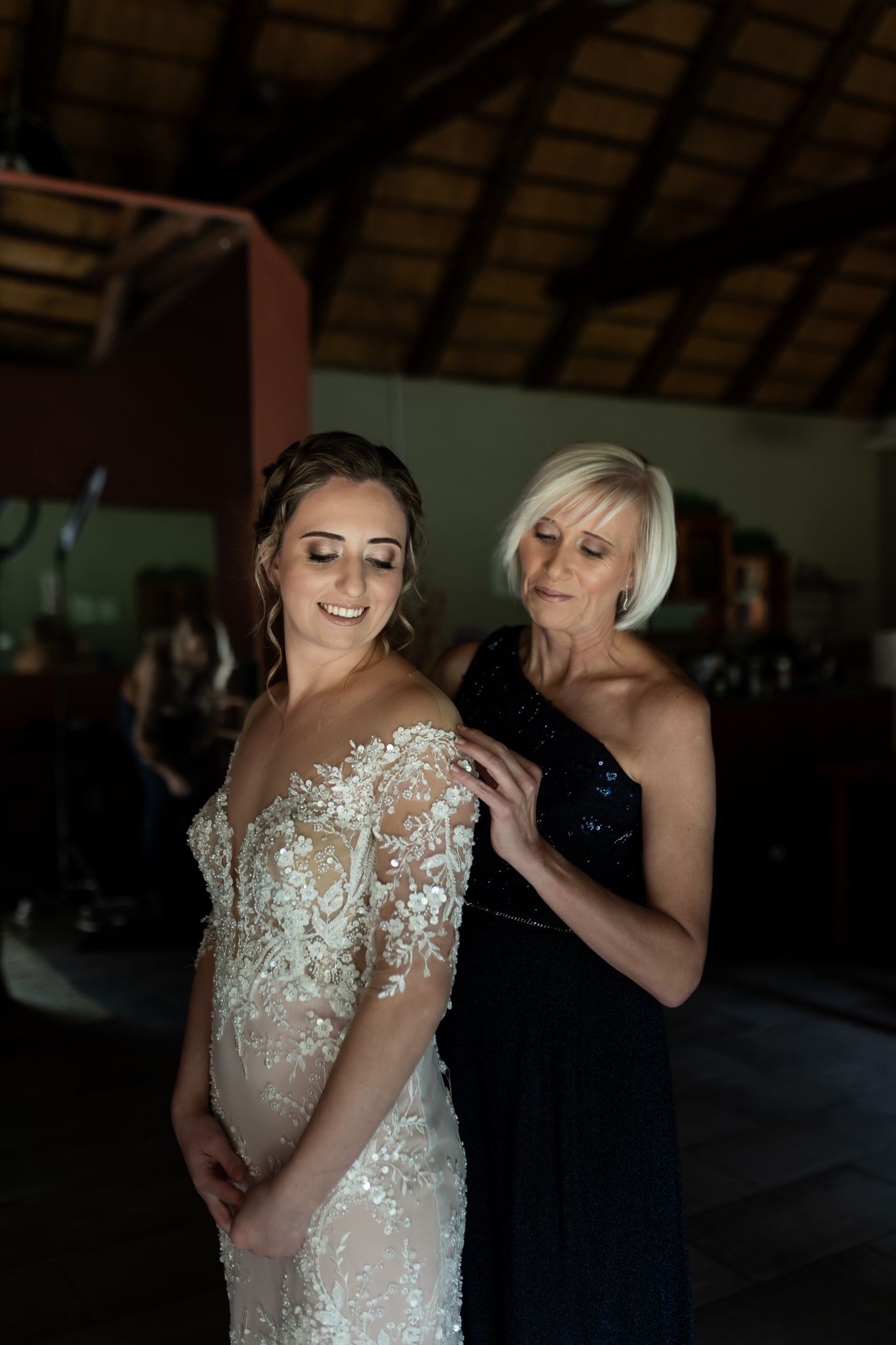 Two people share an intimate moment while preparing for a wedding ceremony.