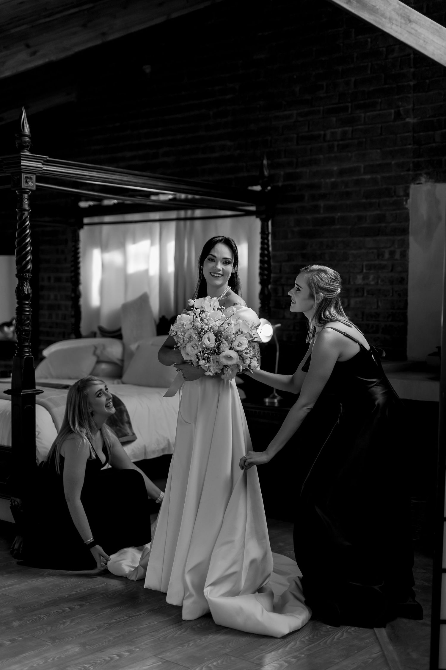 A series of black and white wedding photos showing bridesmaids in light dresses sitting and posing playfully in a rustic venue.