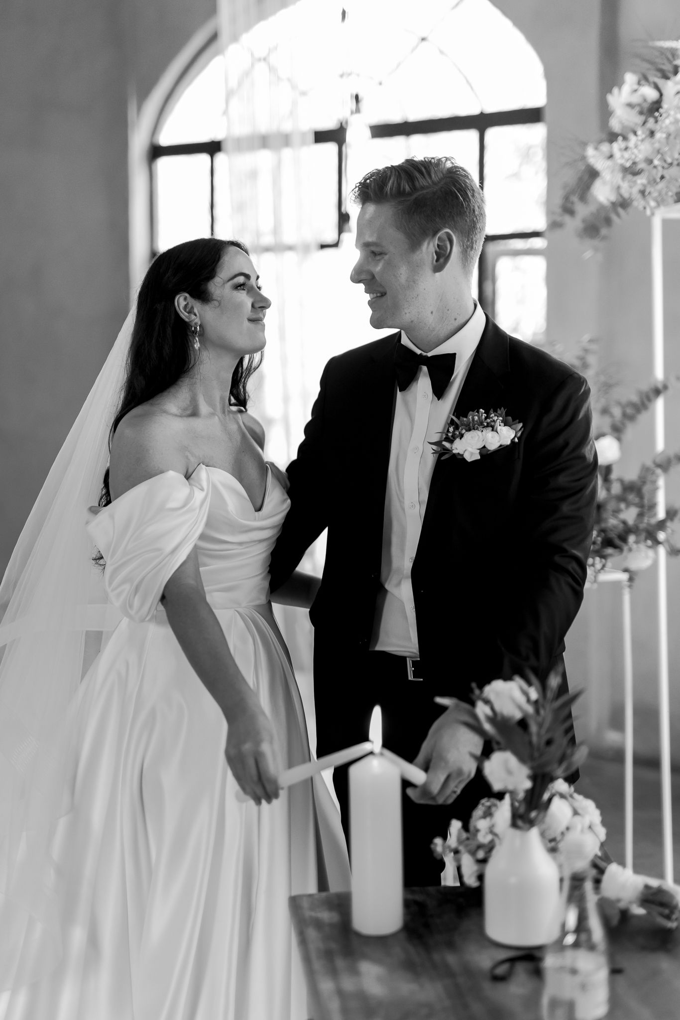 A couple sharing an intimate moment during their wedding ceremony near a unity candle.