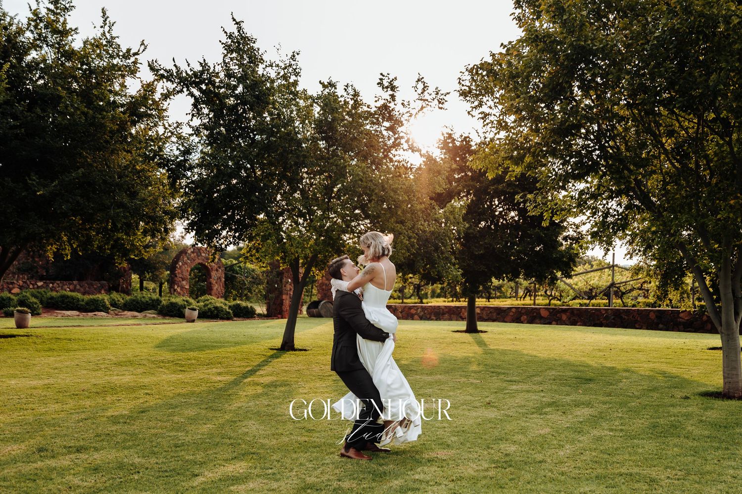 Romantic sunset photos of newlyweds in an open grassy field.