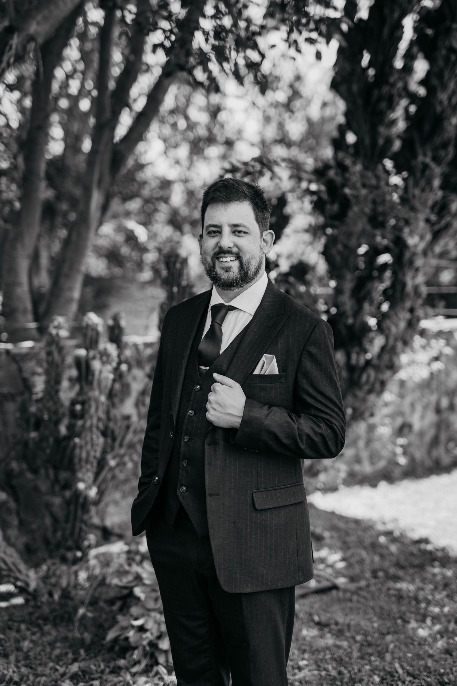 A series of black and white portraits showing joyful expressions and laughter in a wooded outdoor setting.
