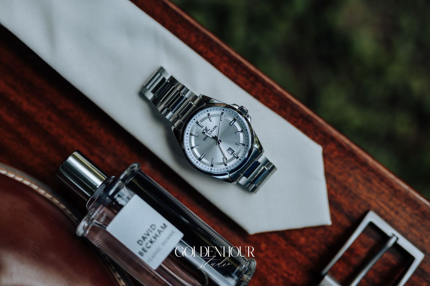 Elegant silver wristwatch with metal band displayed on polished wooden surface.