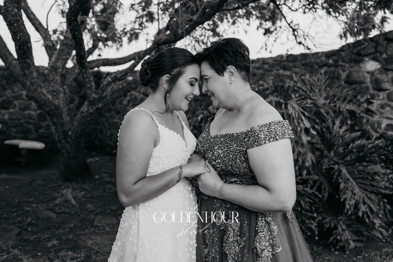 Emotional outdoor wedding ceremony moment with bridesmaids in teal dresses and bride in white gown under trees.