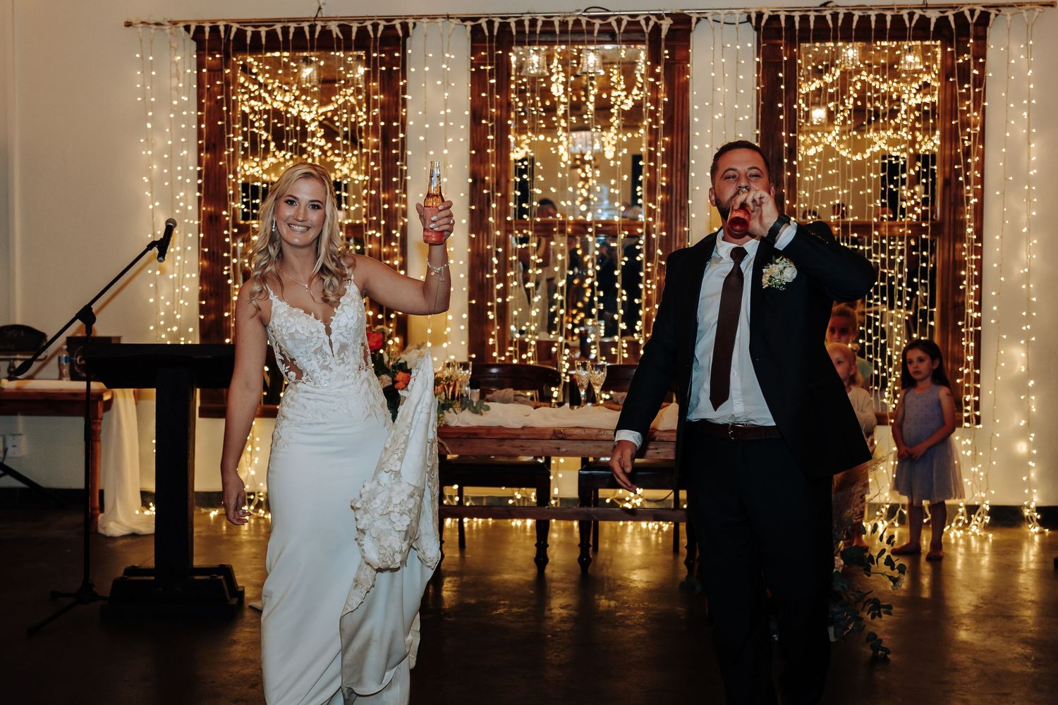 Wedding reception venue decorated with warm string lights and couples dancing on the dance floor.
