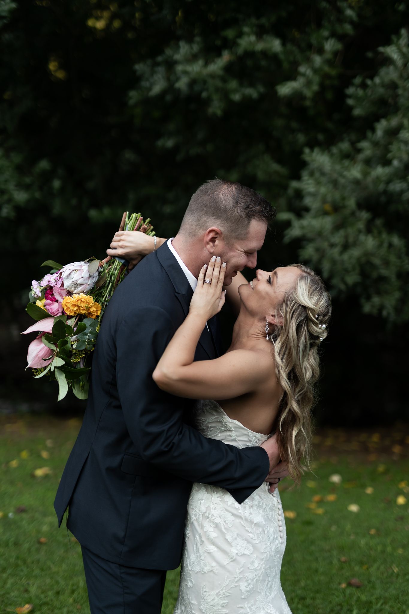 Intimate moment between couple during outdoor wedding photoshoot with colorful florals.