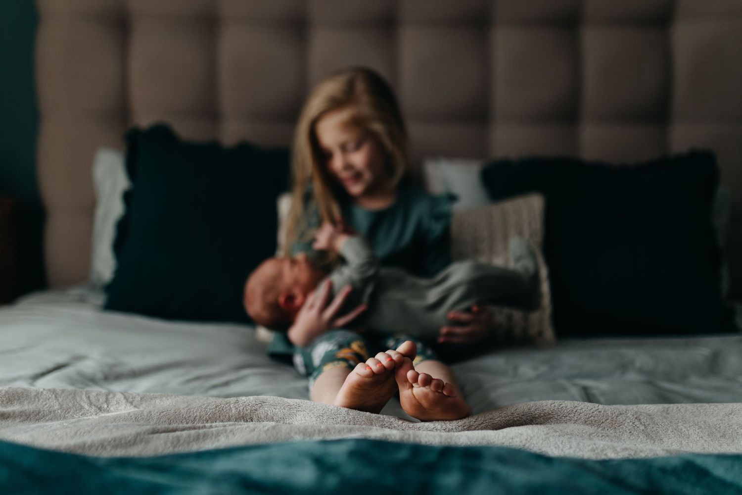 Series of intimate lifestyle photos showing tender moments between parent and newborn on bed.