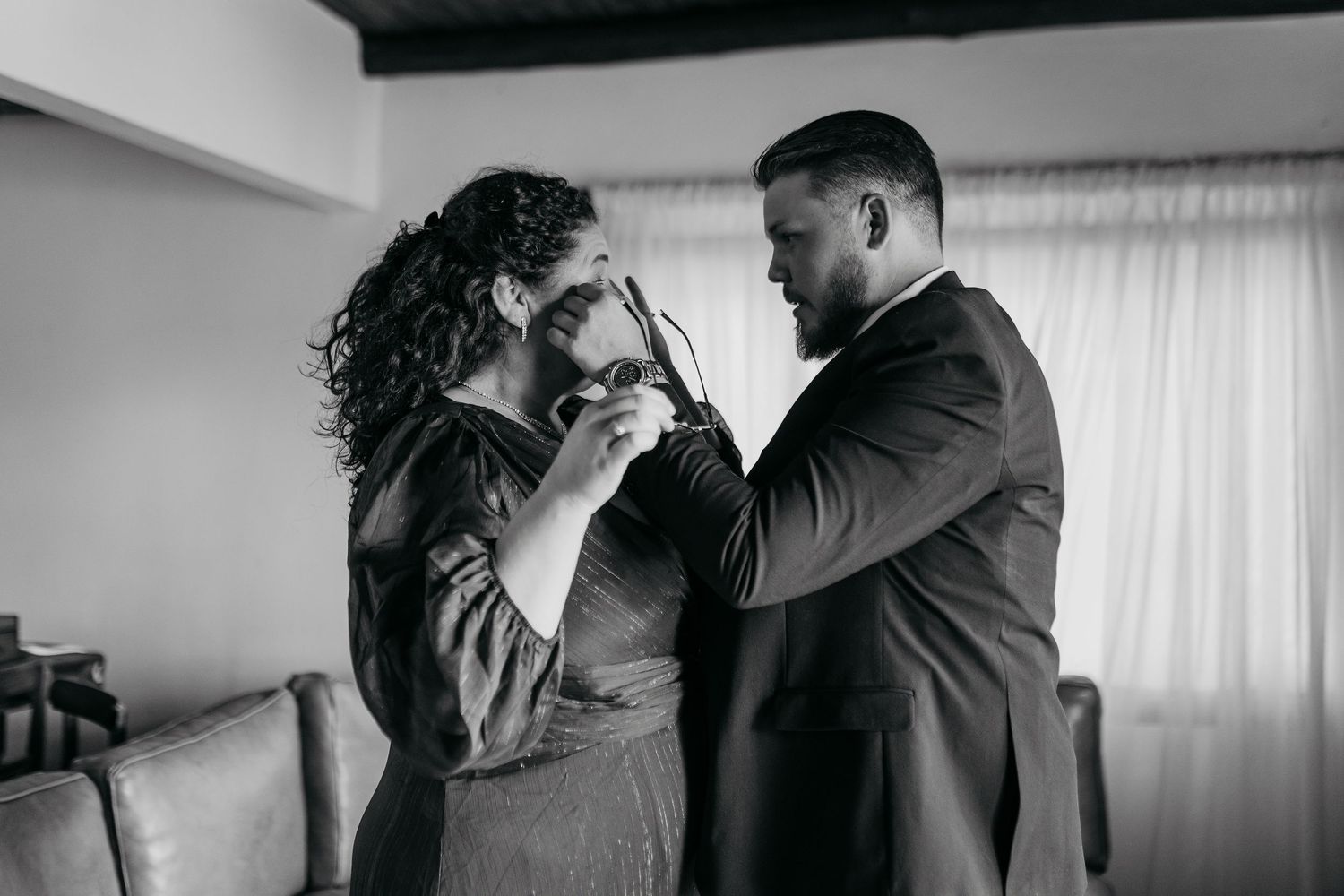 Four black and white images showing intimate moments between a couple dancing or embracing indoors.
