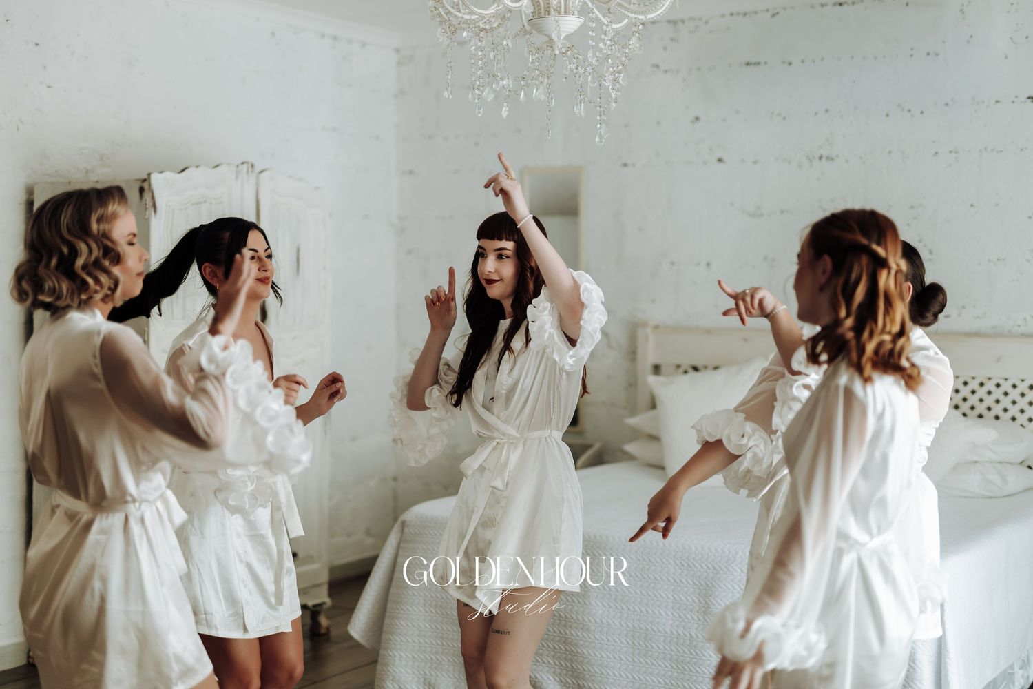 Group wearing white dresses dancing and celebrating in a bright indoor space.