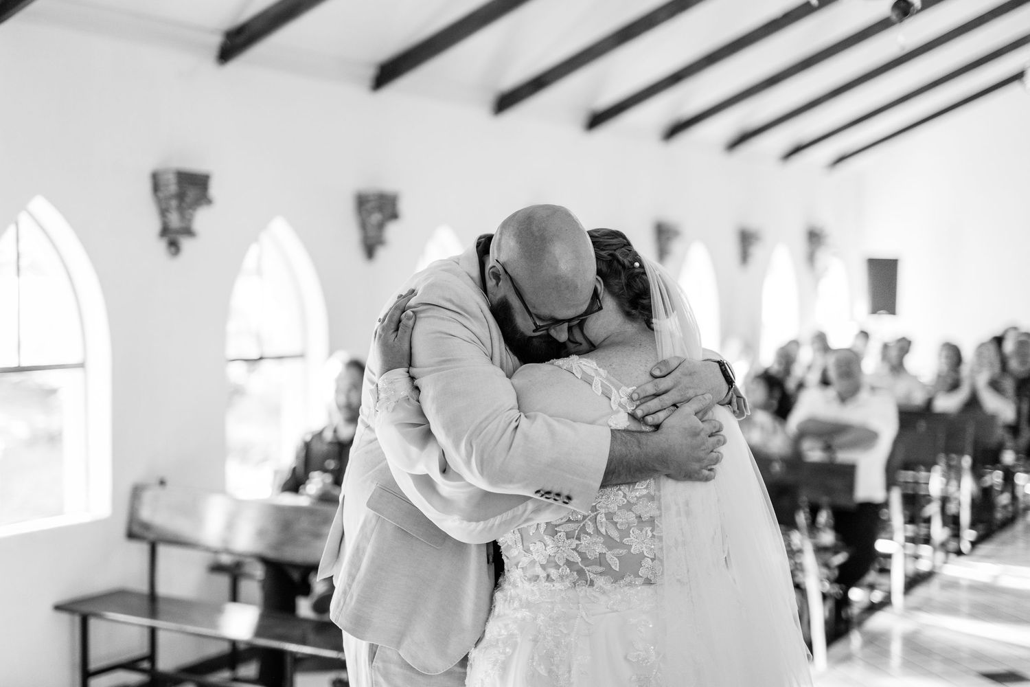 A romantic first dance between newlyweds at an elegant wedding reception surrounded by guests.