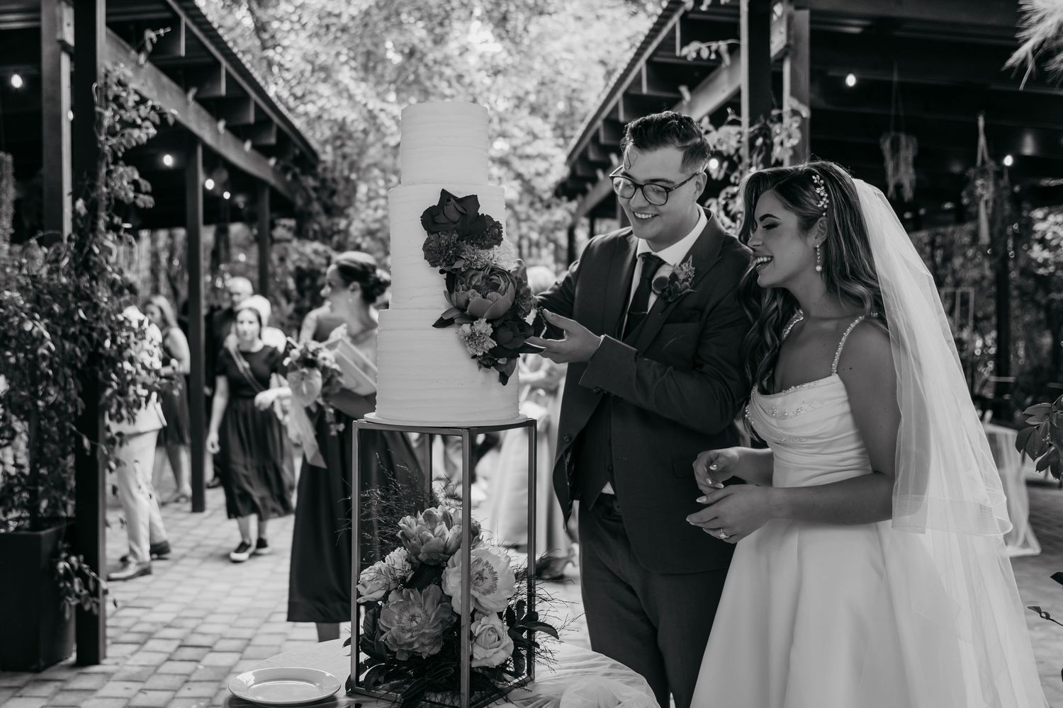 A series of black and white wedding photographs showing intimate moments between couples during an outdoor ceremony.