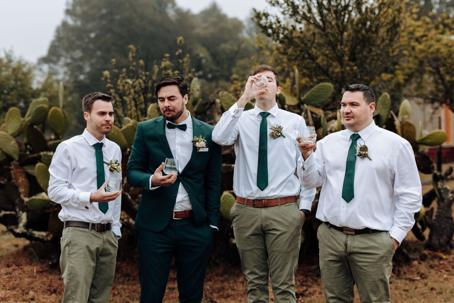 Wedding party enjoying drinks and laughing together in a casual outdoor setting.