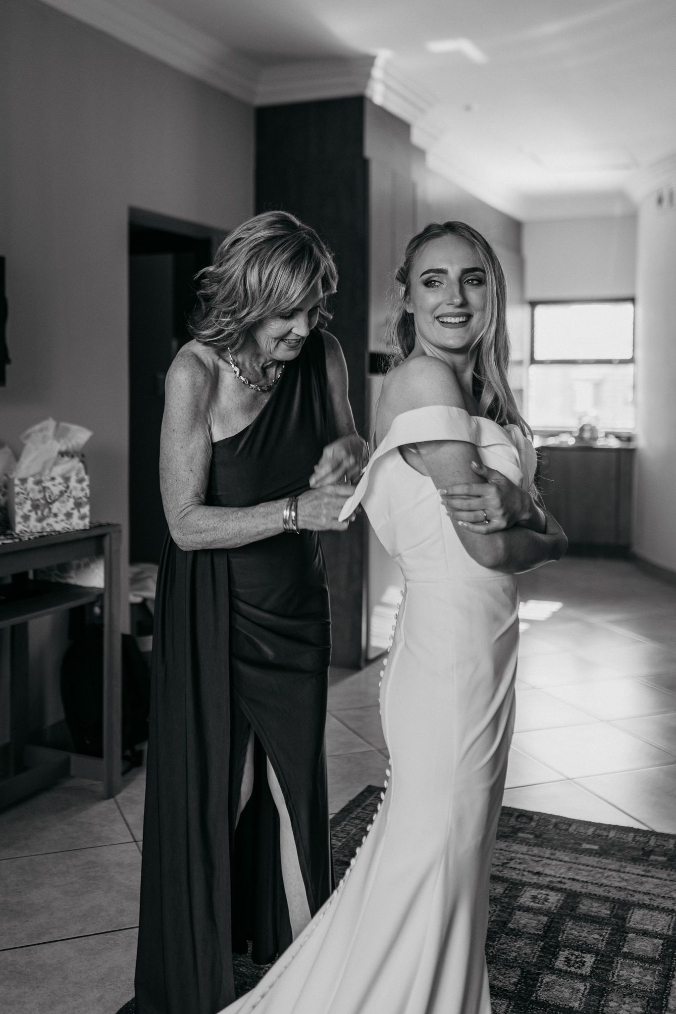 Black and white photograph showing final wedding dress adjustments.