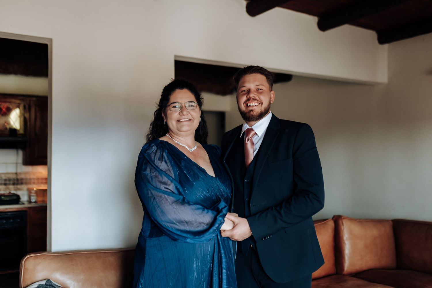 Couple in elegant navy blue dress and dark suit embrace in a candid lifestyle photo sequence.