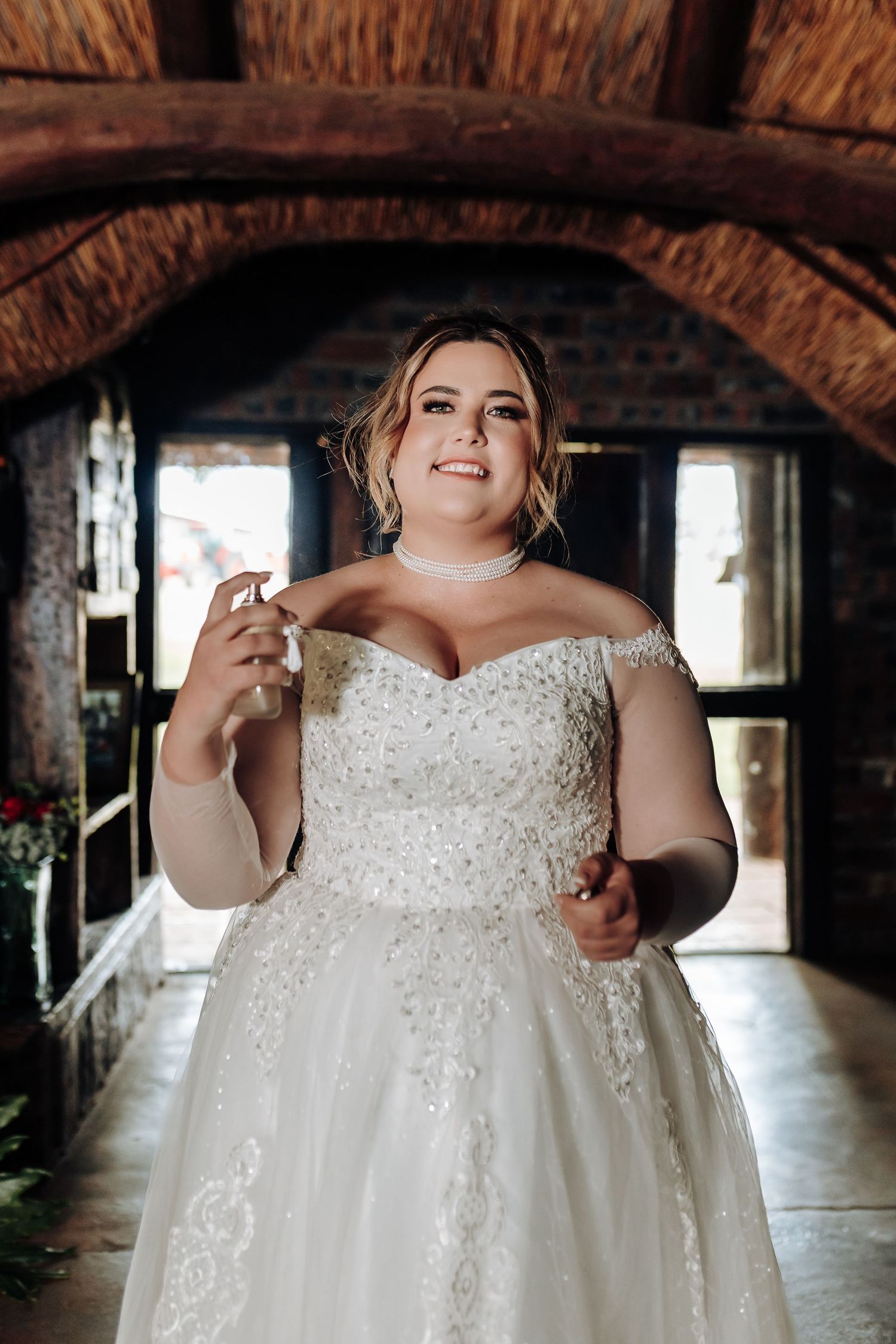 Beautiful wedding dress with sequined bodice sparkles in rustic brick venue as someone shows off its elegant details.