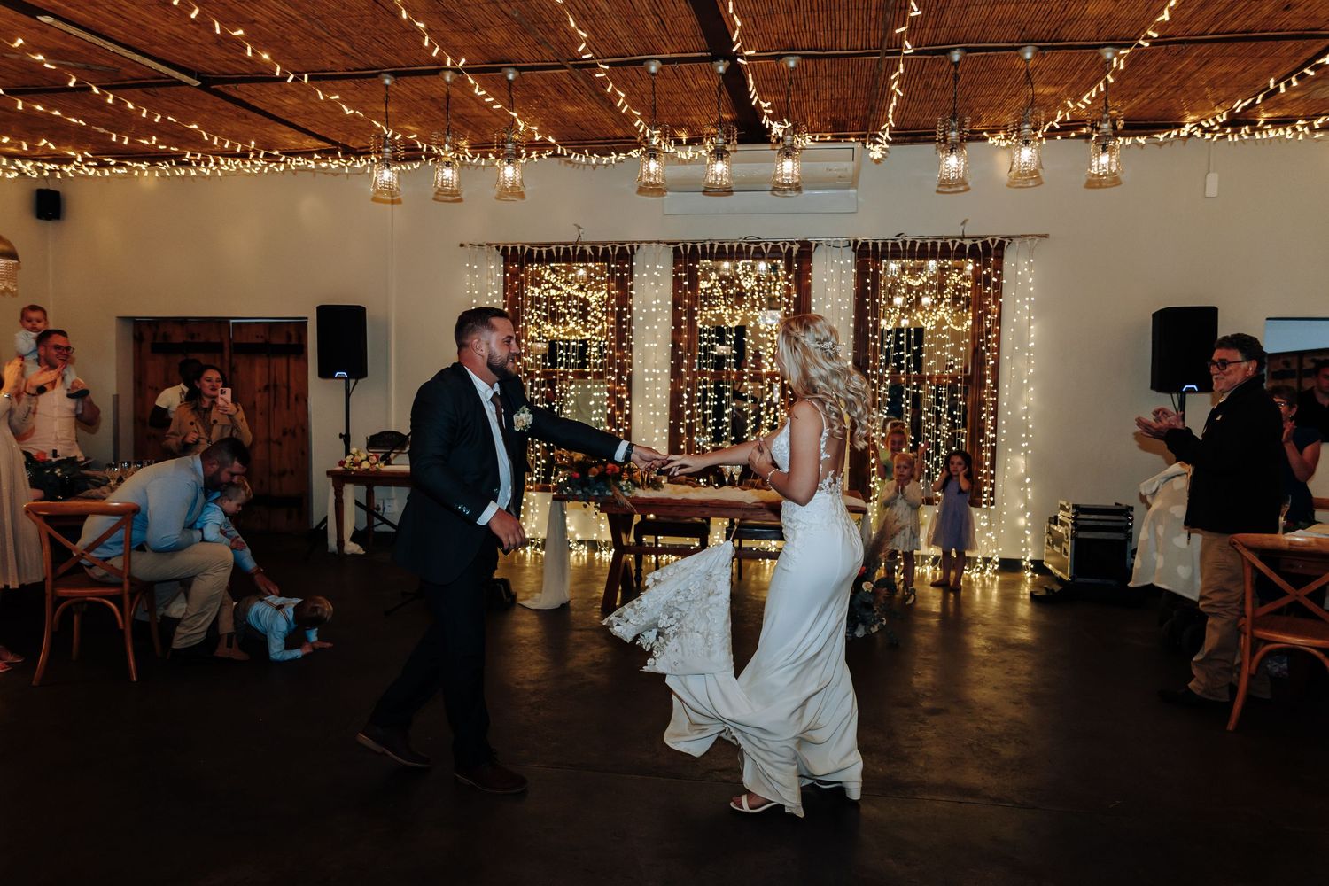 Indoor wedding reception space with twinkling fairy lights strung across the ceiling creating a romantic ambiance.