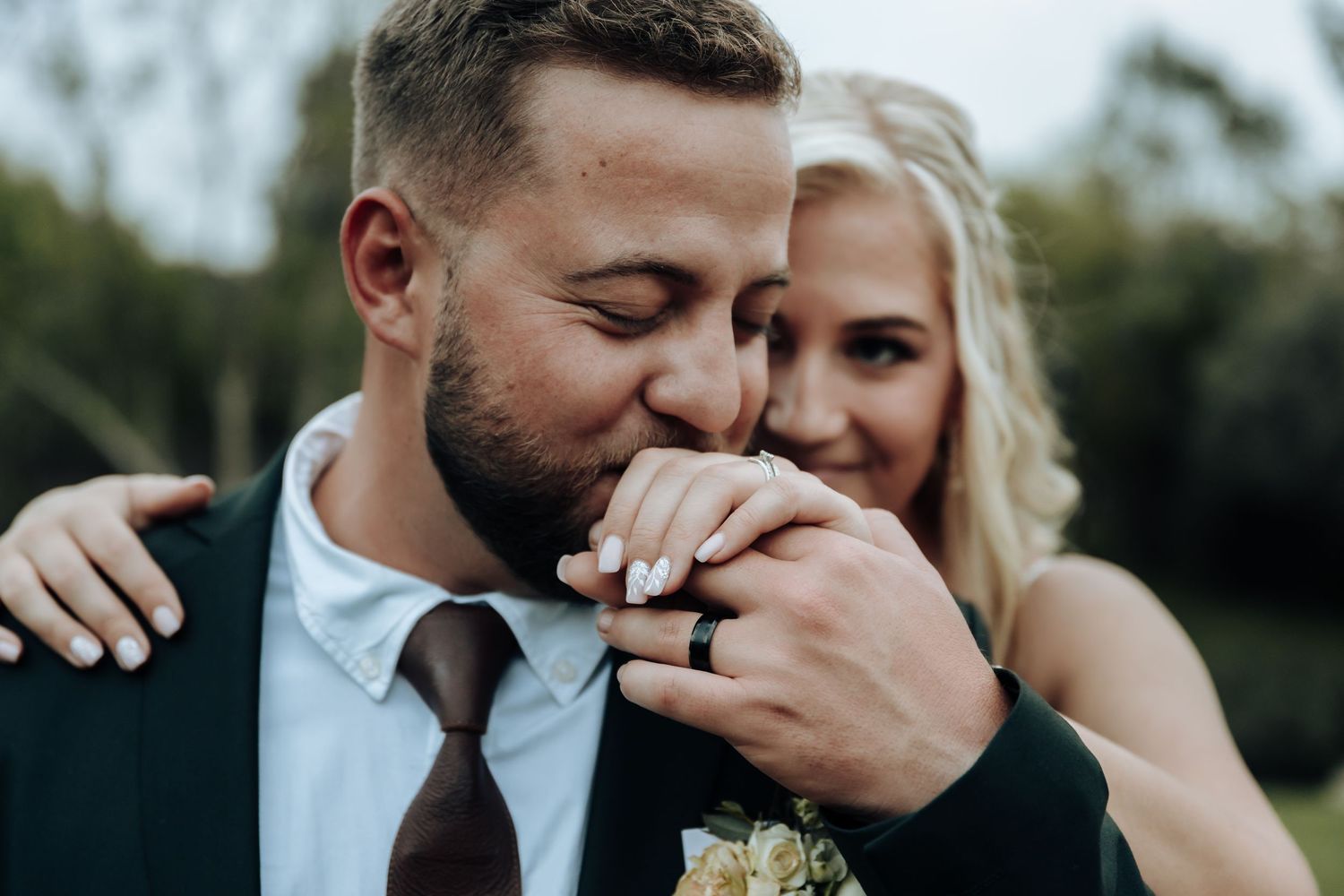 A romantic wedding couple shares intimate moments together in a garden setting during their photo session.
