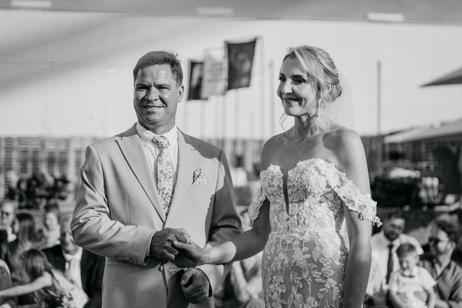 Black and white portrait of newlyweds during their rustic outdoor celebration.