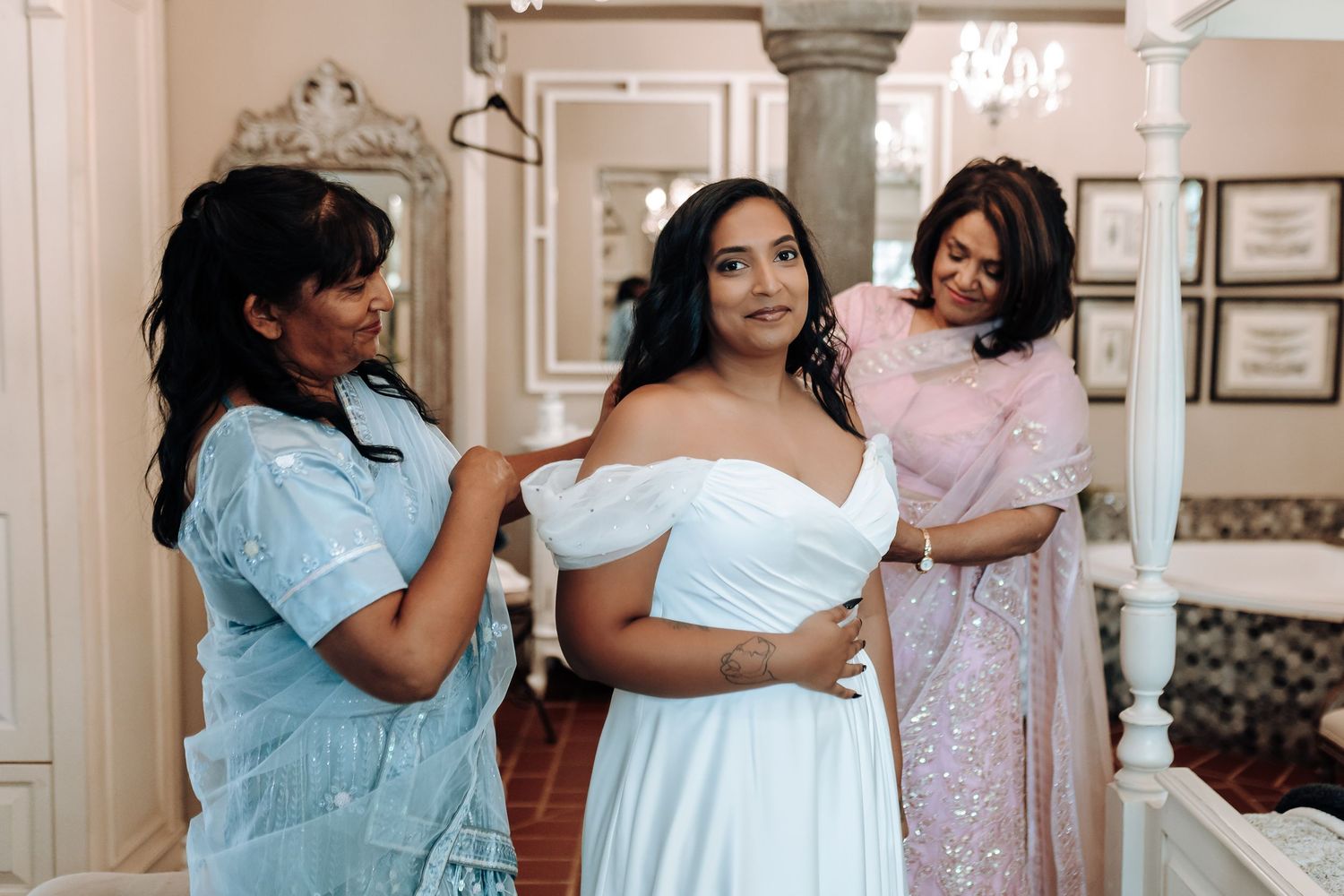 Getting ready scene in elegant dressing room with formal dresses and ornate decor.