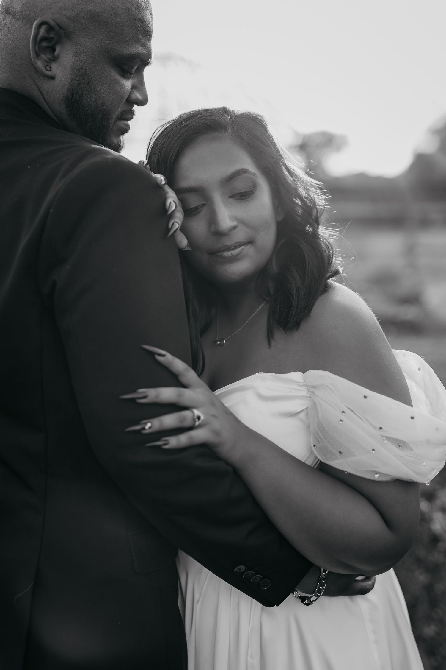 Black and white intimate portrait of couple embracing during their wedding photoshoot.