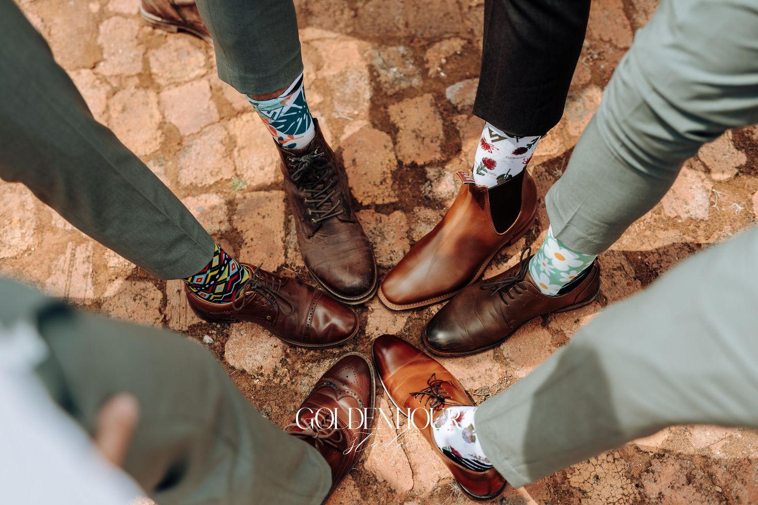 Wedding party showing off their dress shoes and boots in a fun group photo.