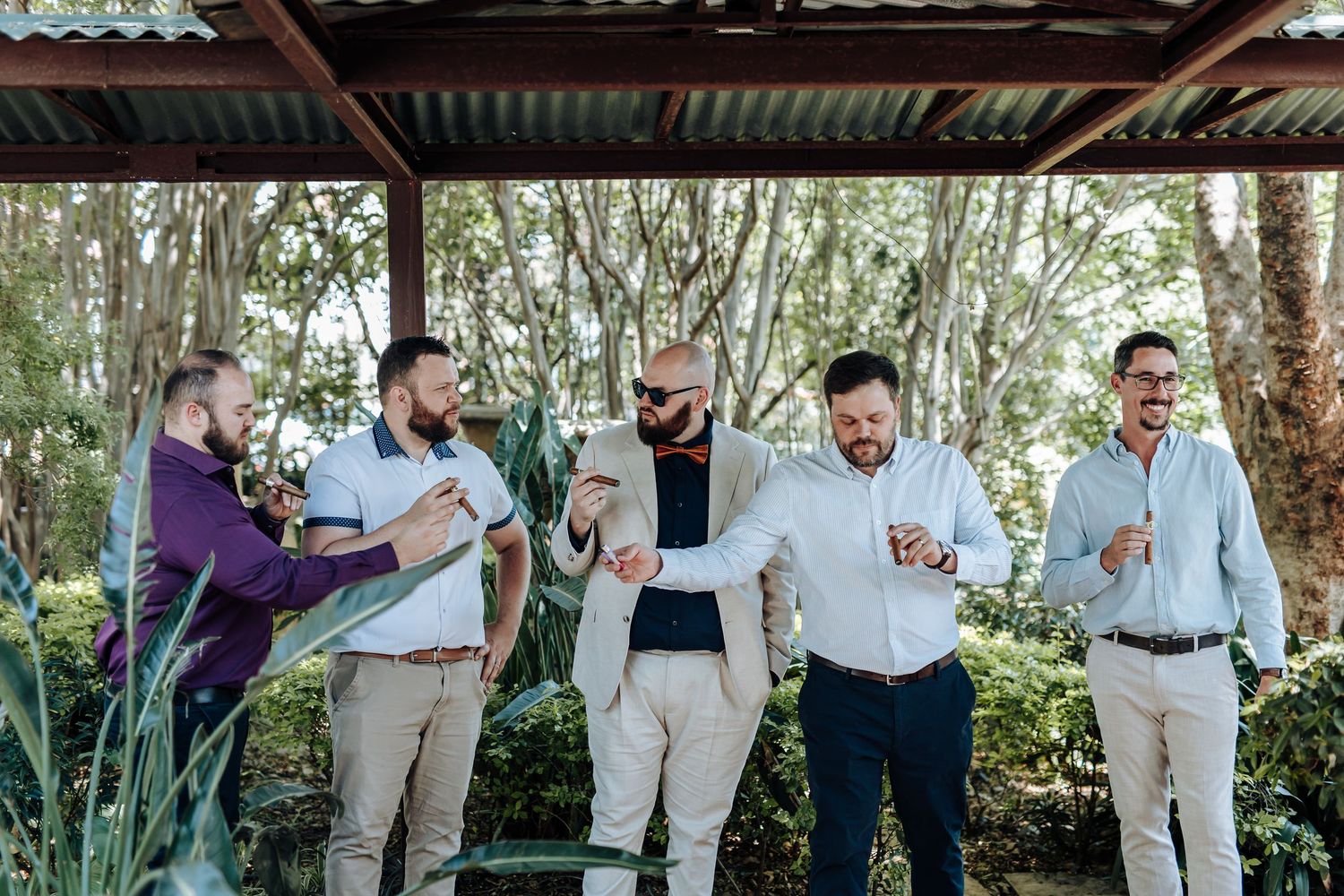 Wedding party celebrates with champagne toasts in a lush garden setting during outdoor reception.