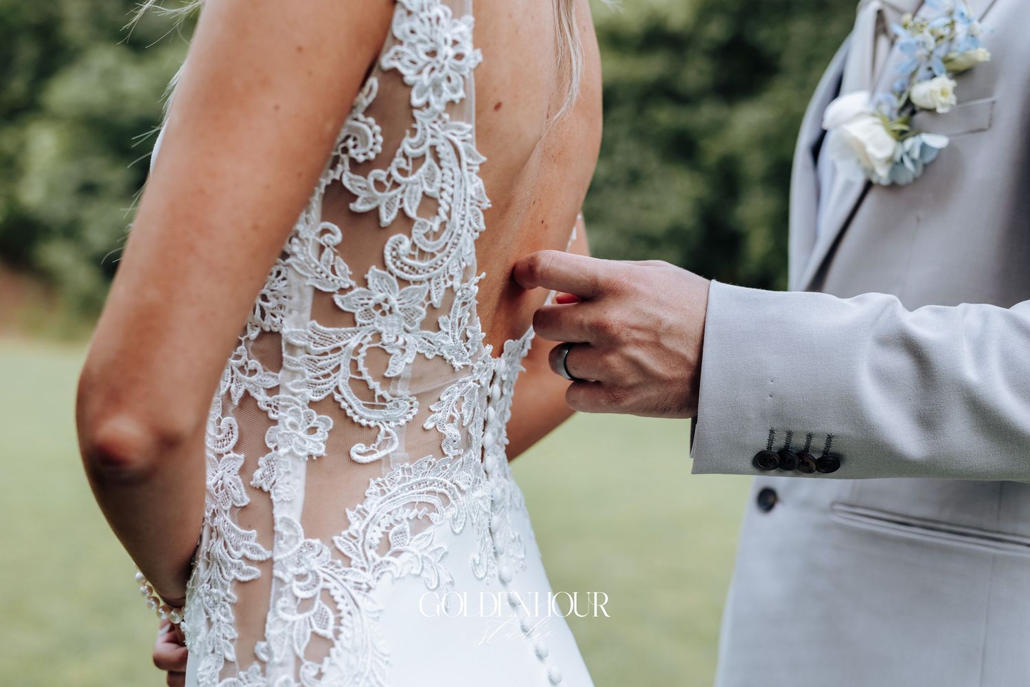 Close-up detail of intricate lace pattern on back of wedding dress with buttons.