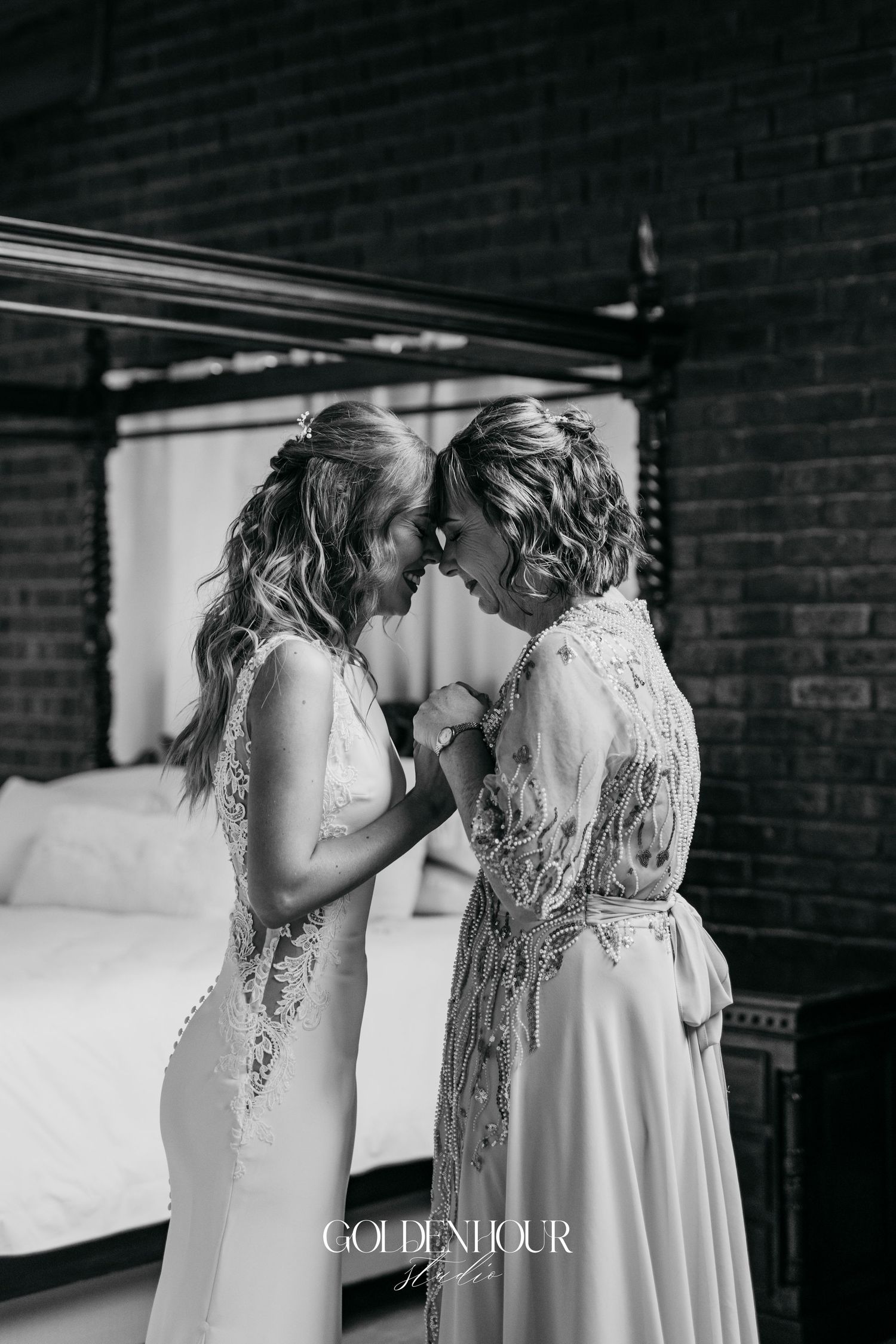 An intimate black and white moment against a brick wall backdrop.
