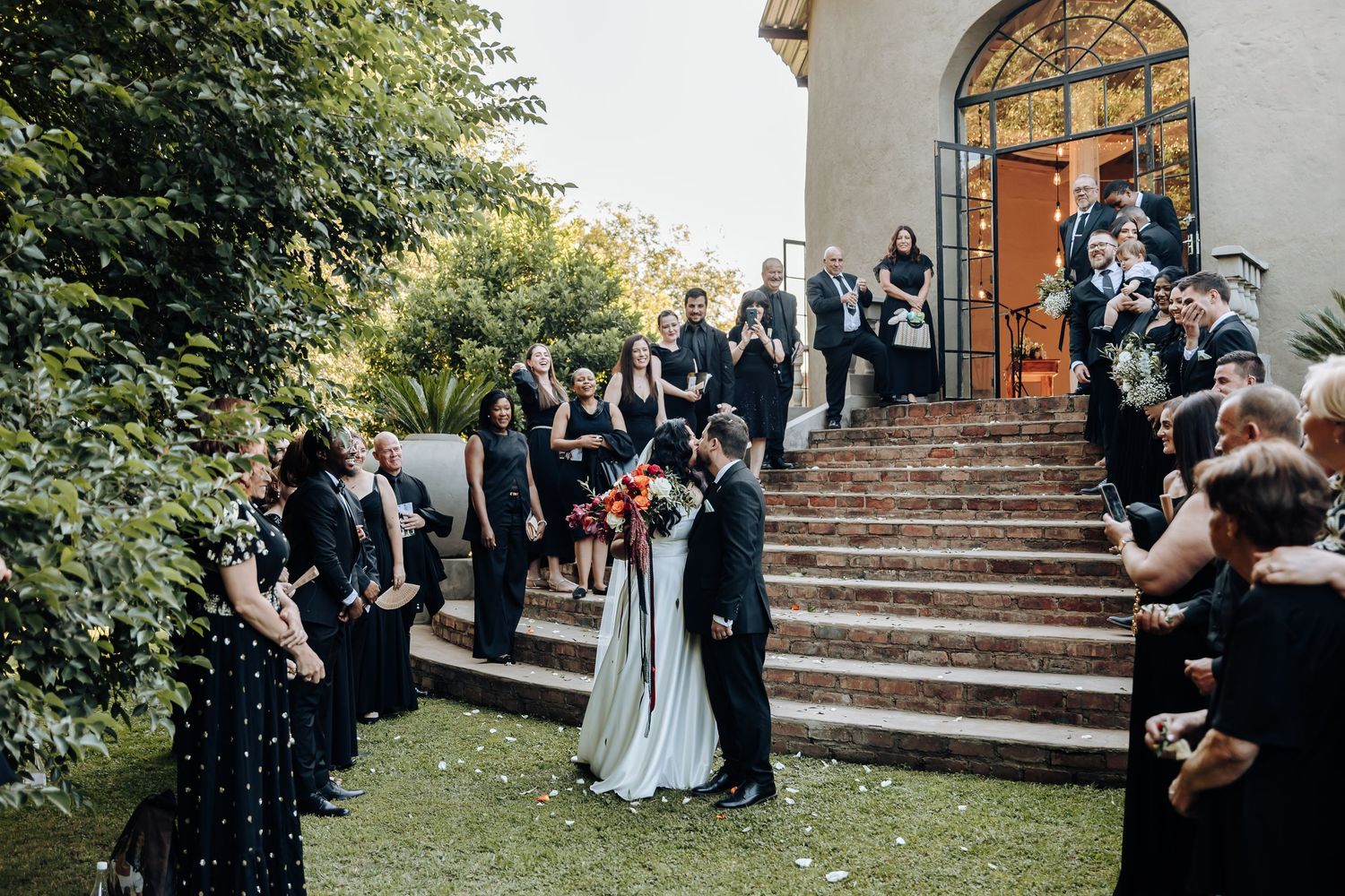 Wedding ceremony taking place at a charming outdoor venue with stone steps.