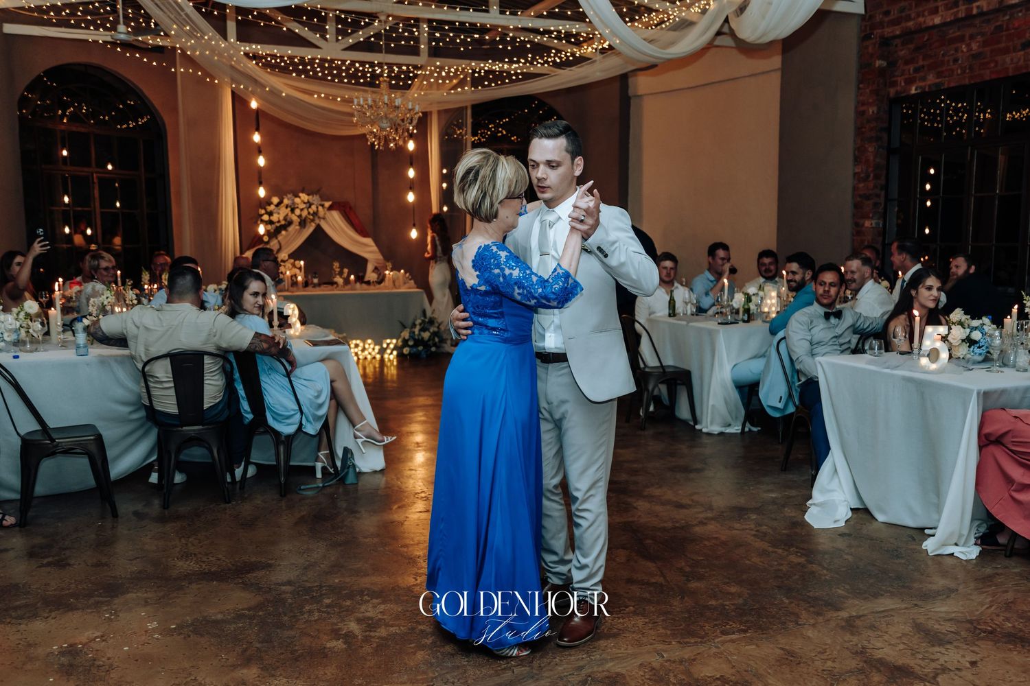 Wedding reception dance floor scene with guests celebrating in an elegantly decorated venue.