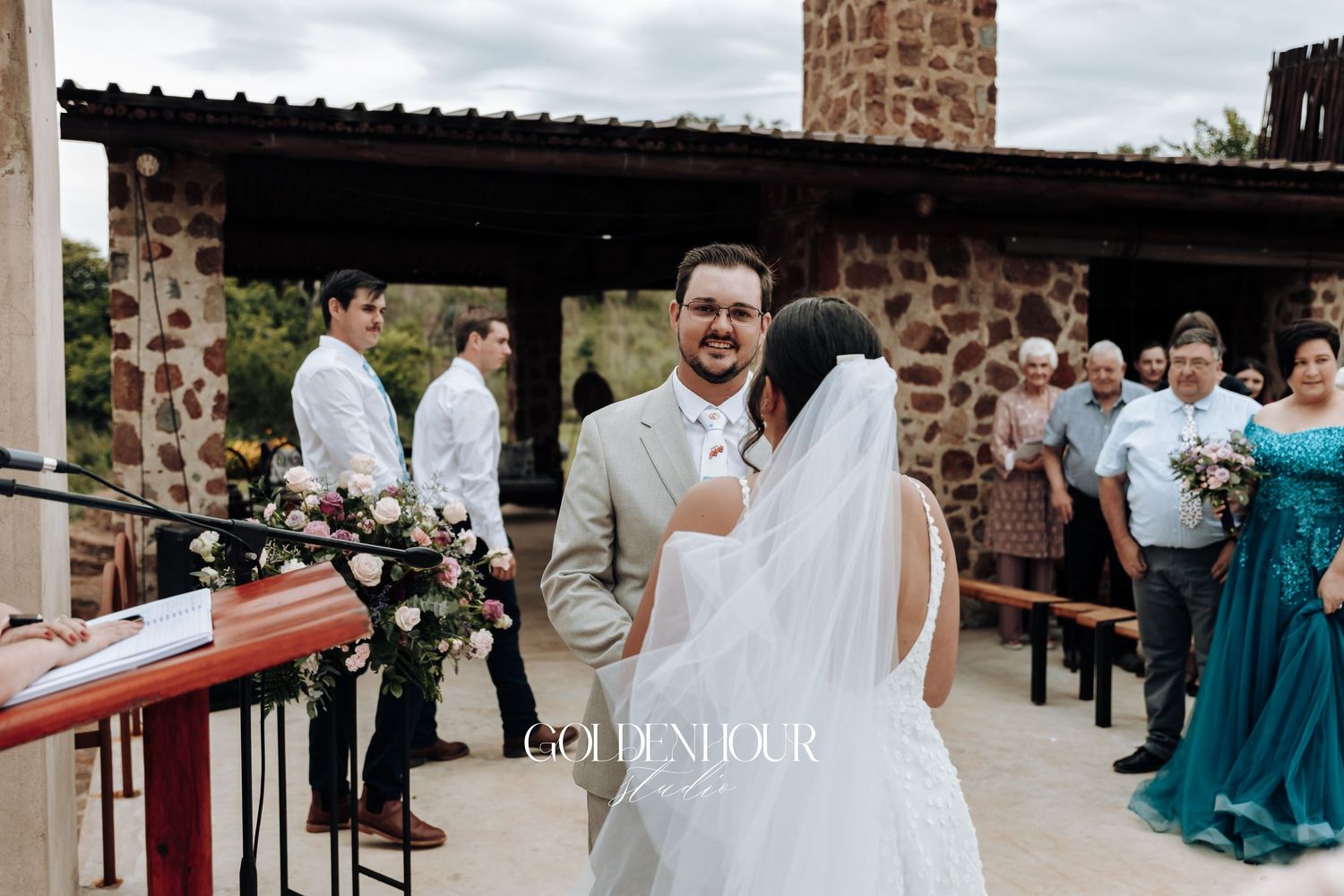 Wedding celebration with guests at an outdoor stone venue.
