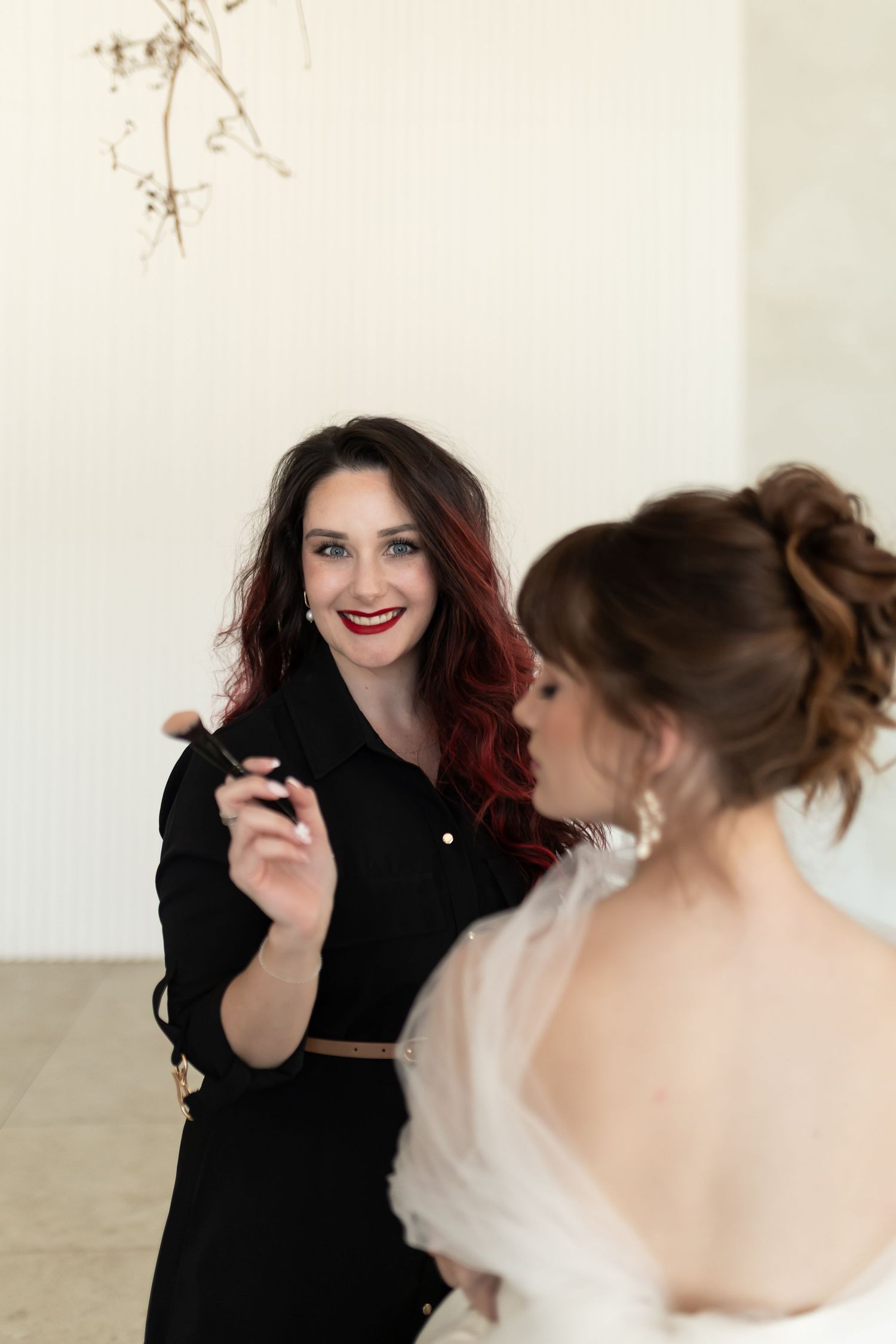 Two people share a moment during a formal event, with one wearing black and the other in white.
